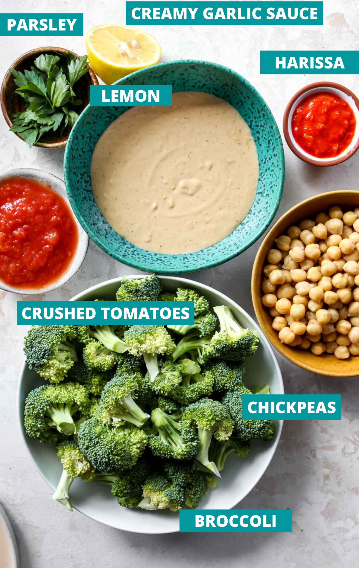 Recipe ingredients in separate bowls on a white board with blue labels.
