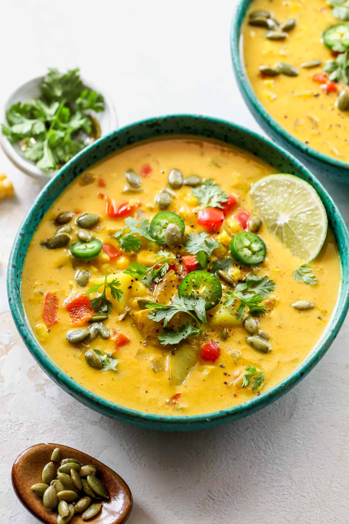 Serving of corn chowder poured in a bowl and topped with garnishes