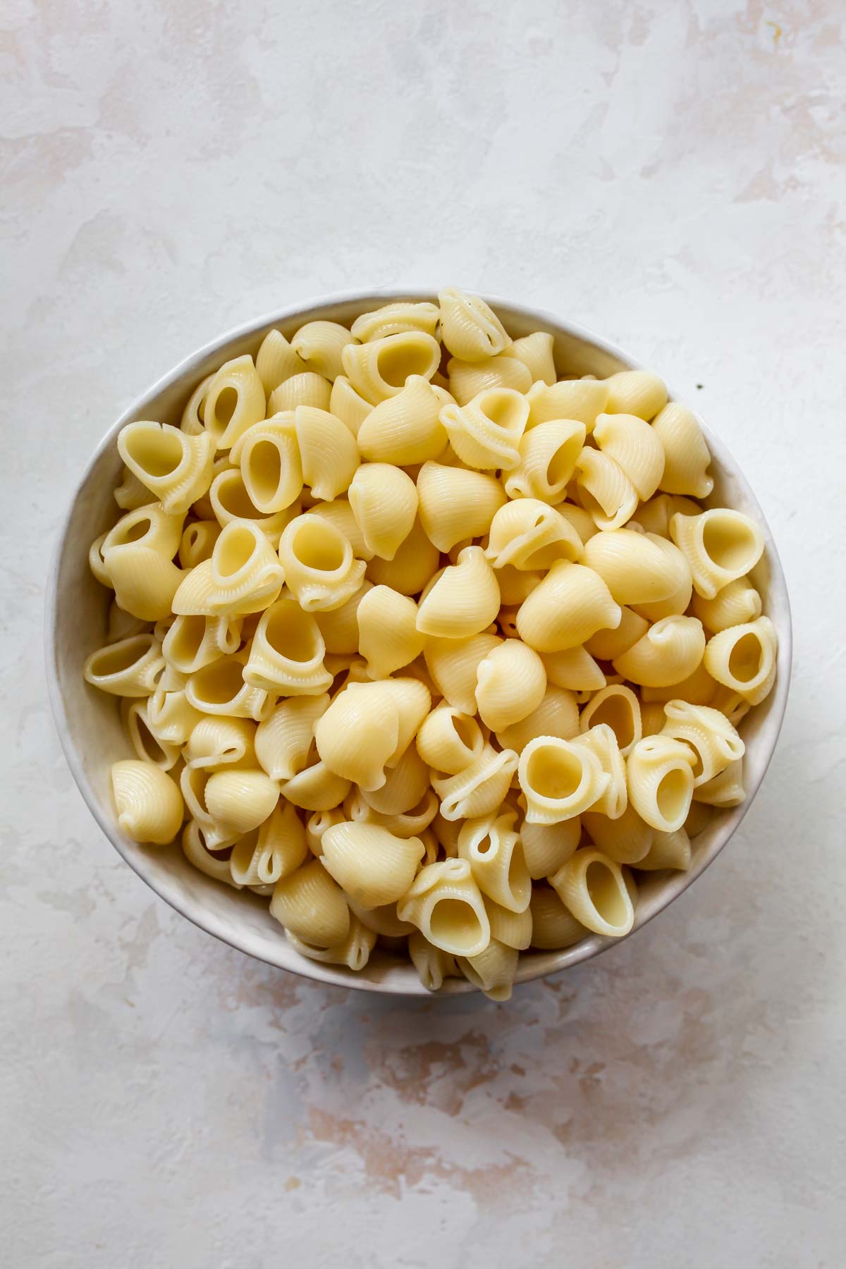 Boiled shellbows being drained in a colander