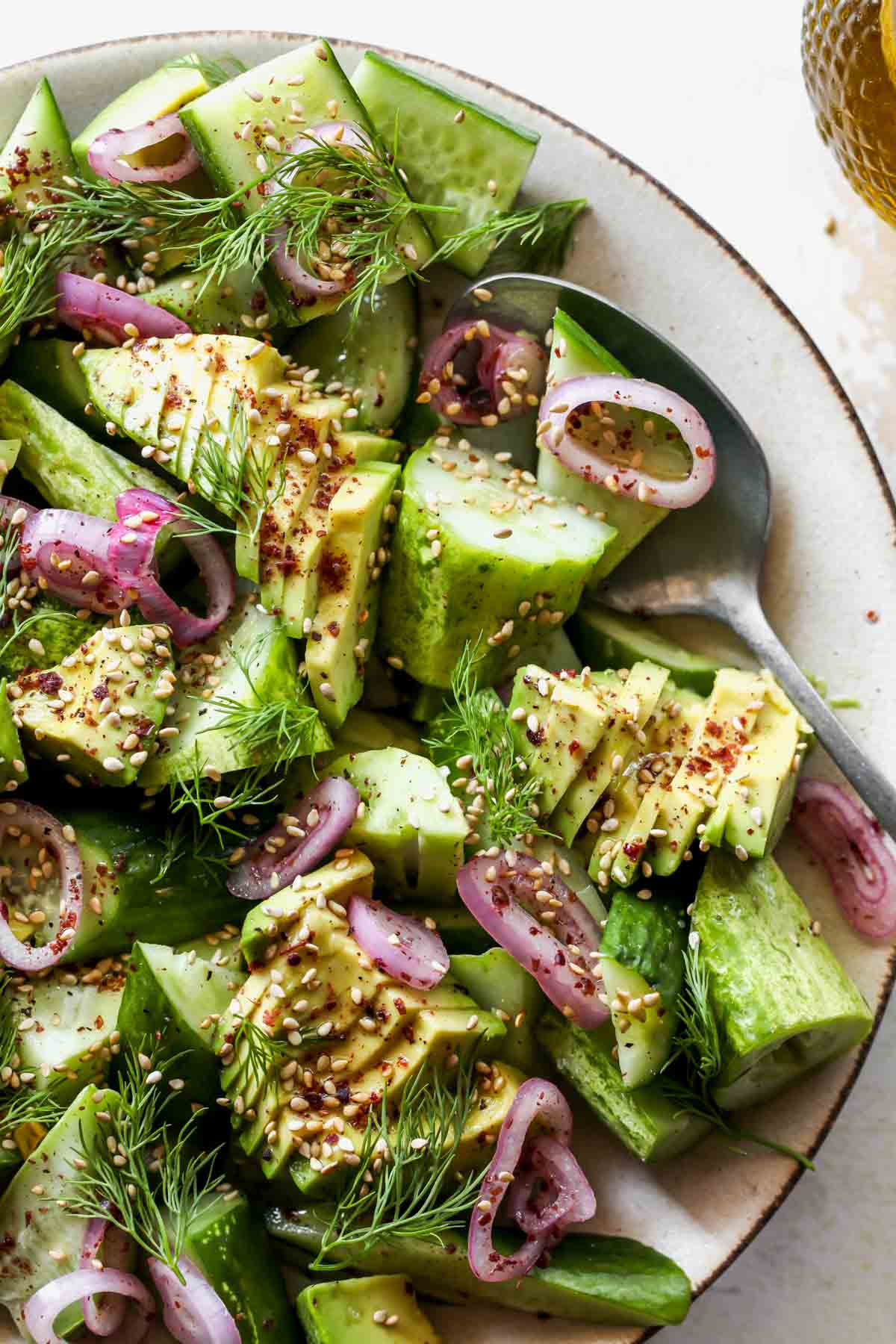 A serving spoon scooping up a portion of salad