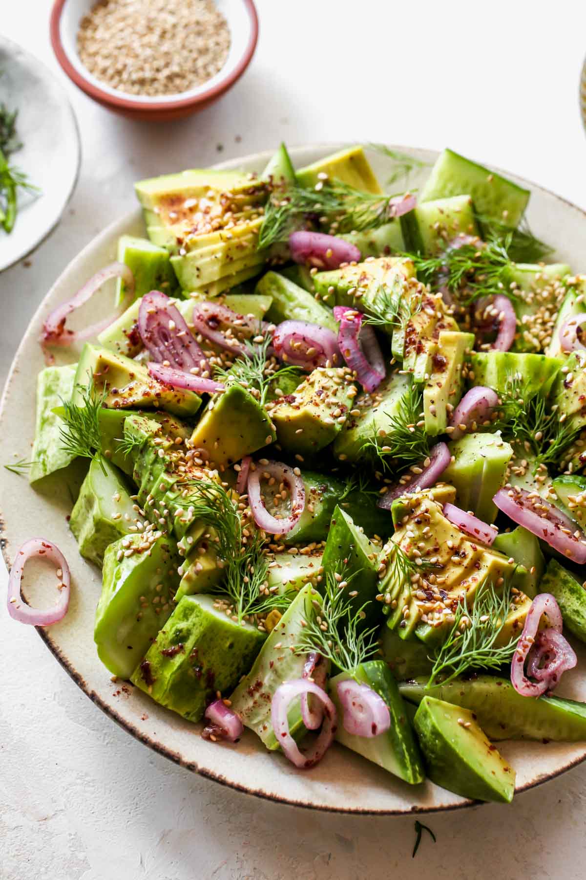 Cucumber and avocado salad topped with sesame seeds and dill