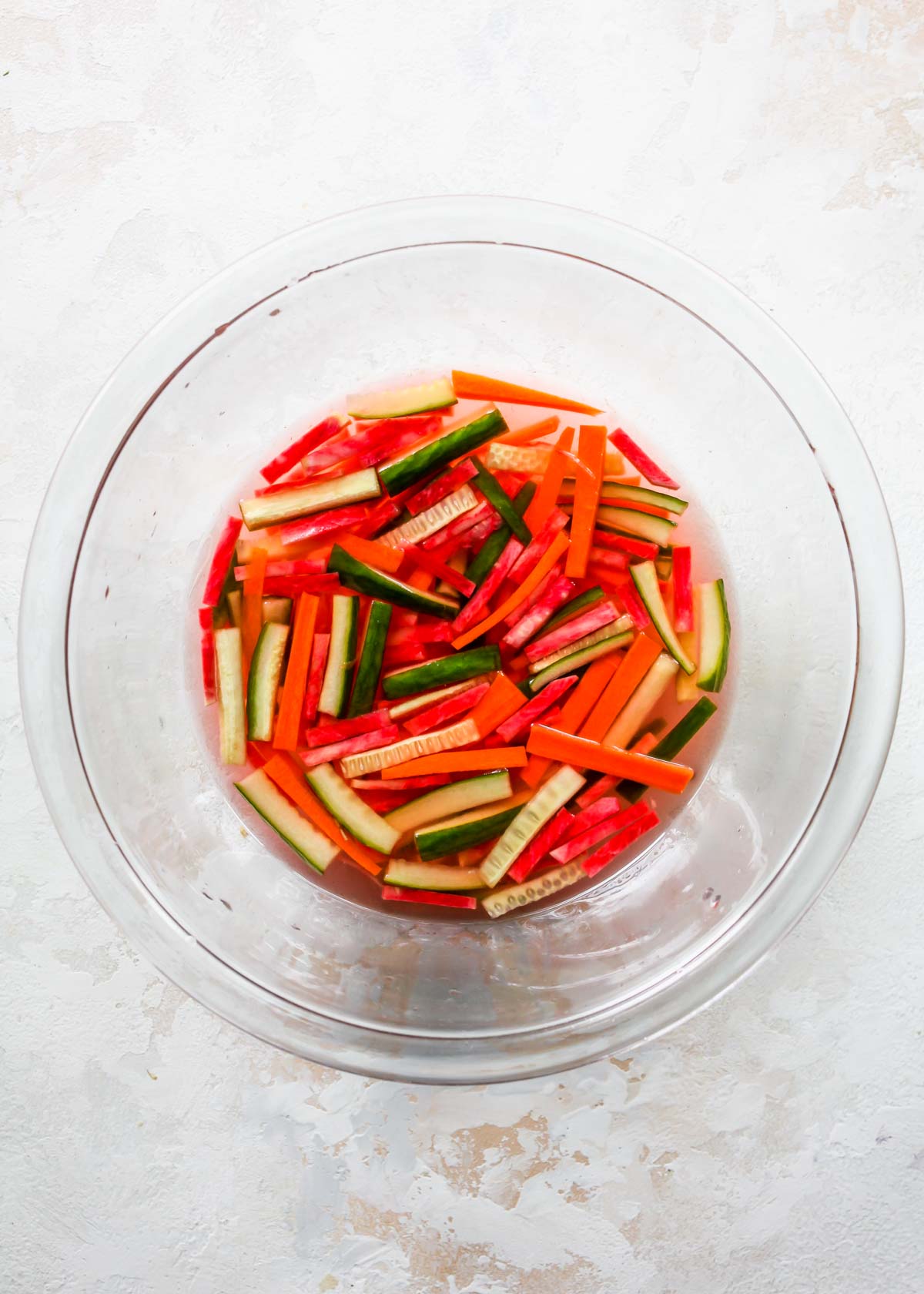 Carrots, cucumber, and radish pickling in a bowl