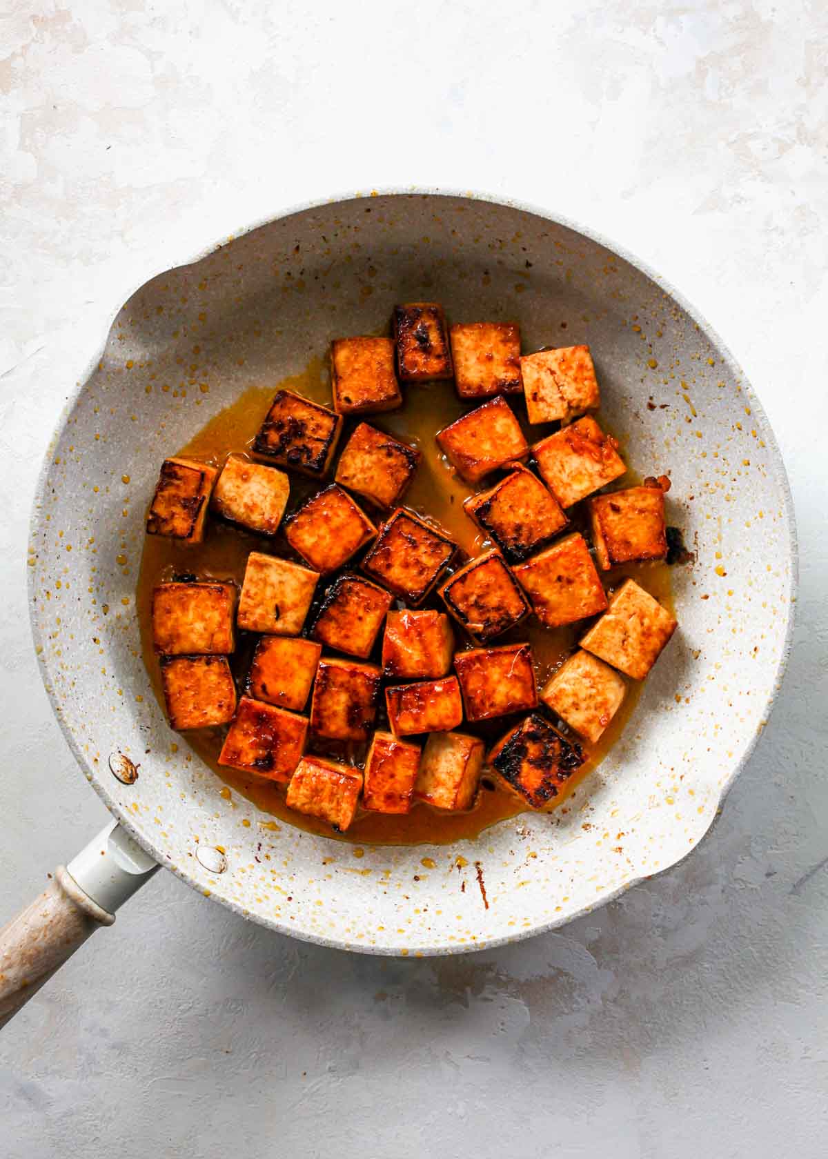 Tofu being sautéed in a skillet