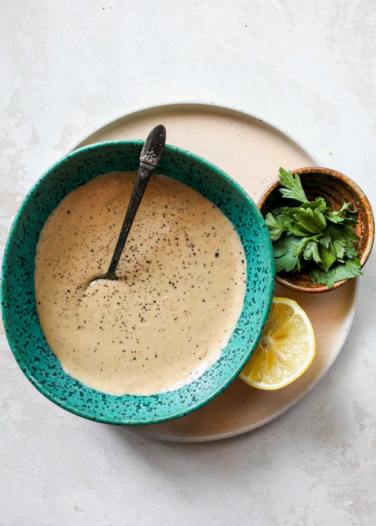 Creamy garlic sauce in a teal bowl