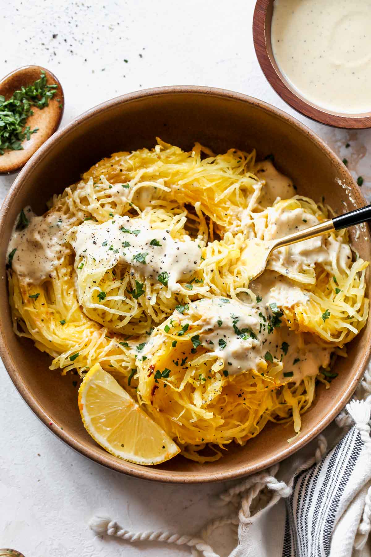 A fork twirling into a bowl of spaghetti squash alfredo