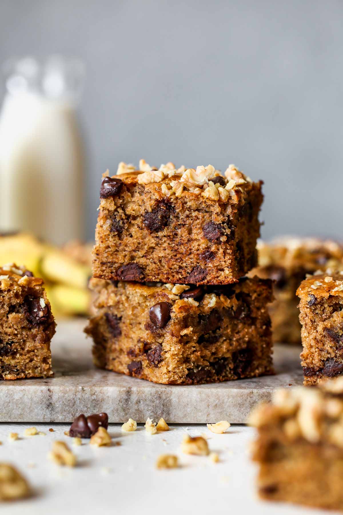 Two chocolate chip banana bars stacked on a board