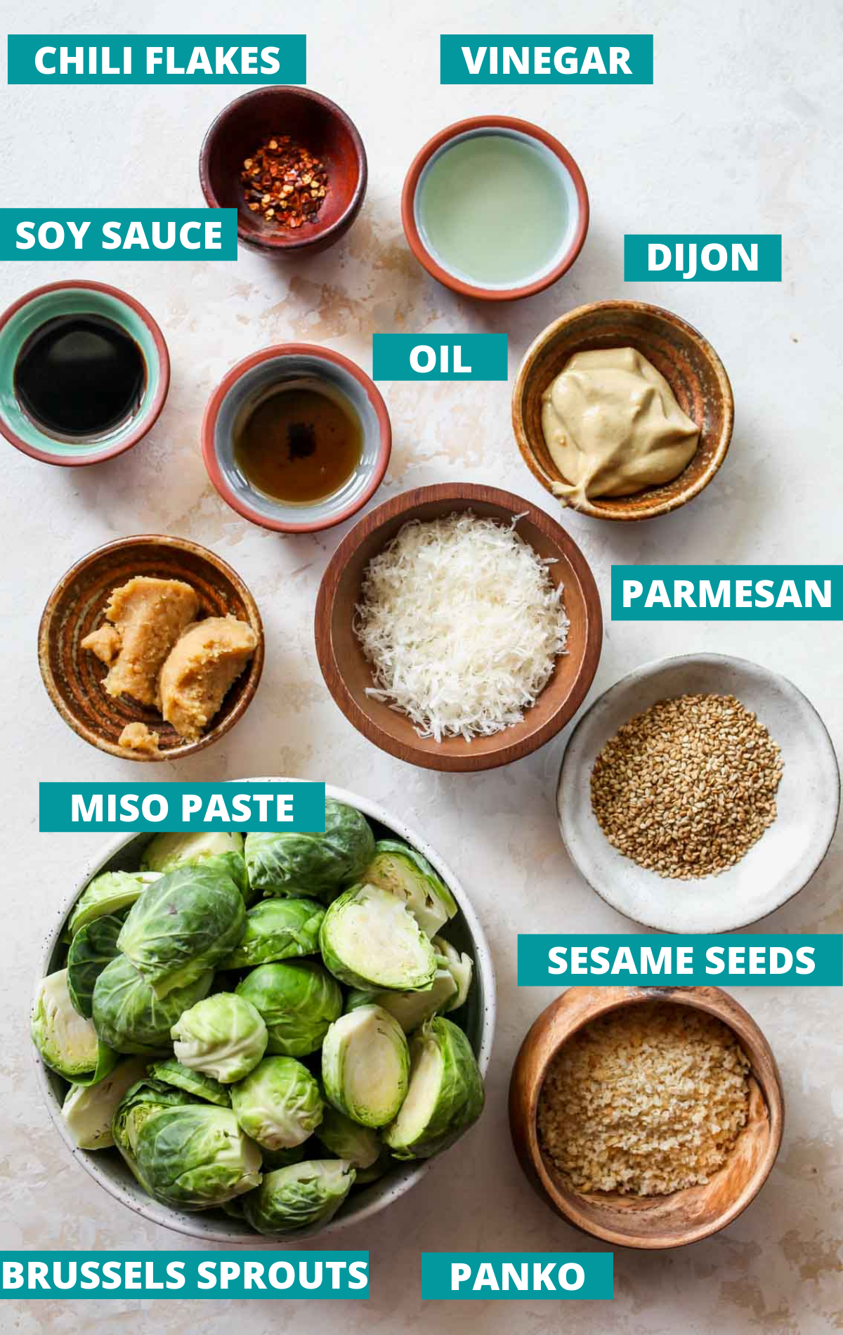 Recipe ingredients in separate bowls on a white board with blue labels
