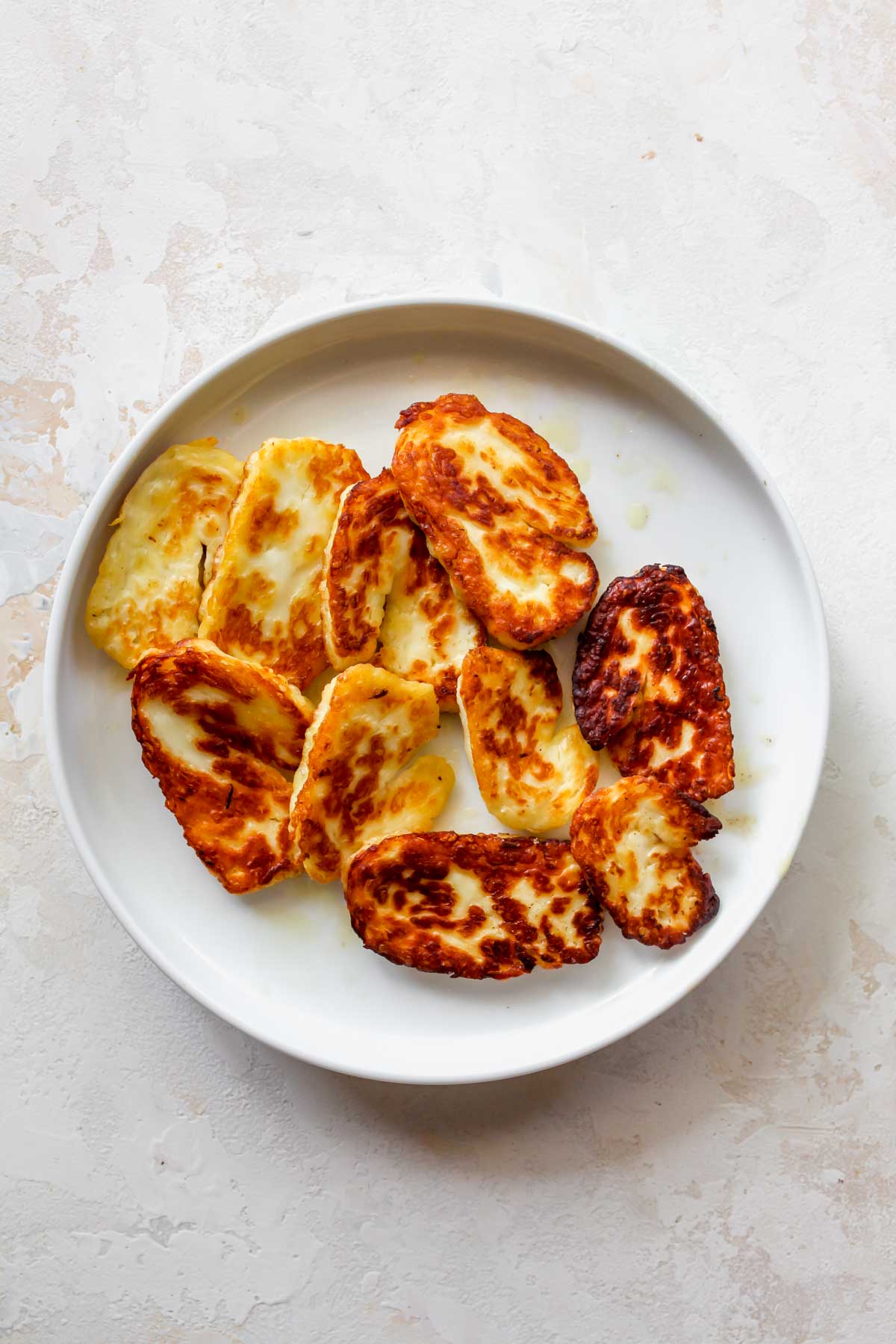 Slabs of fried halloumi cheese on a white plate