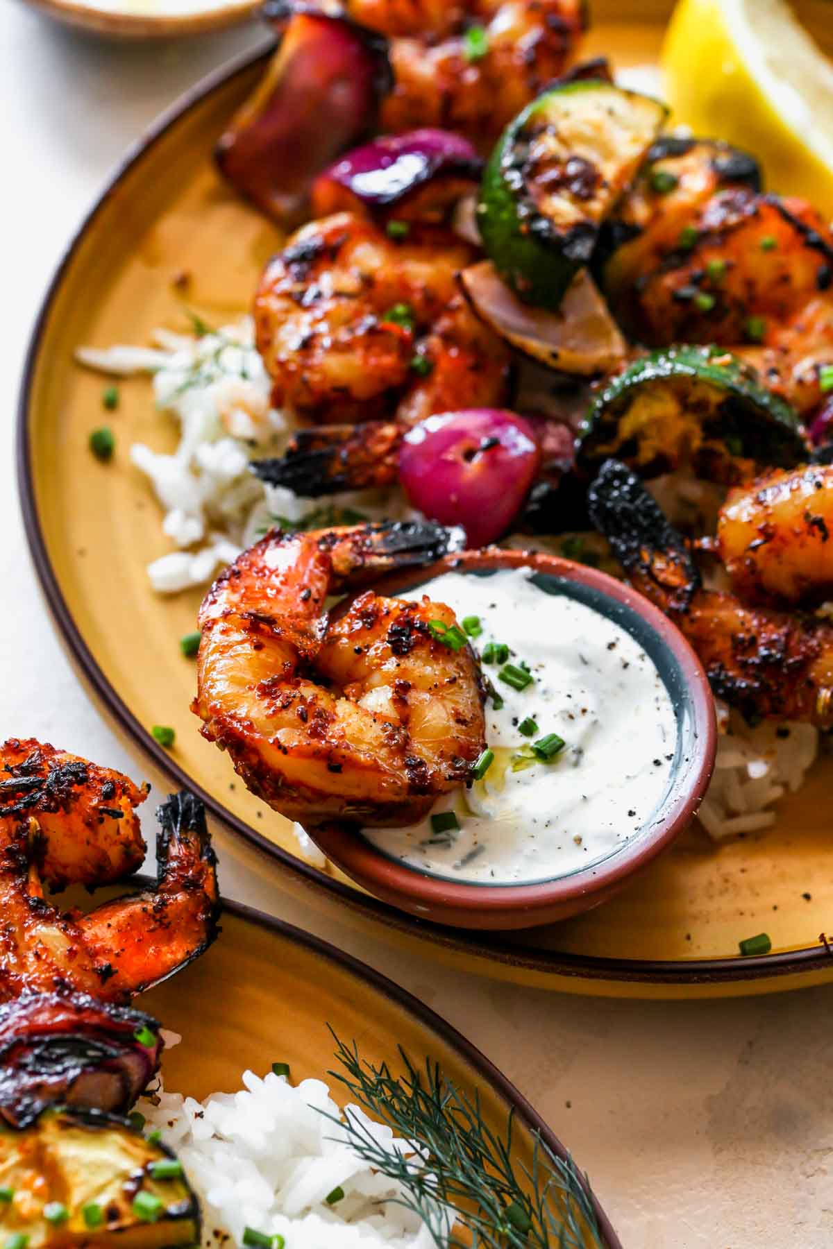 A piece of shrimp being dipped into Lemon-Dill Sauce
