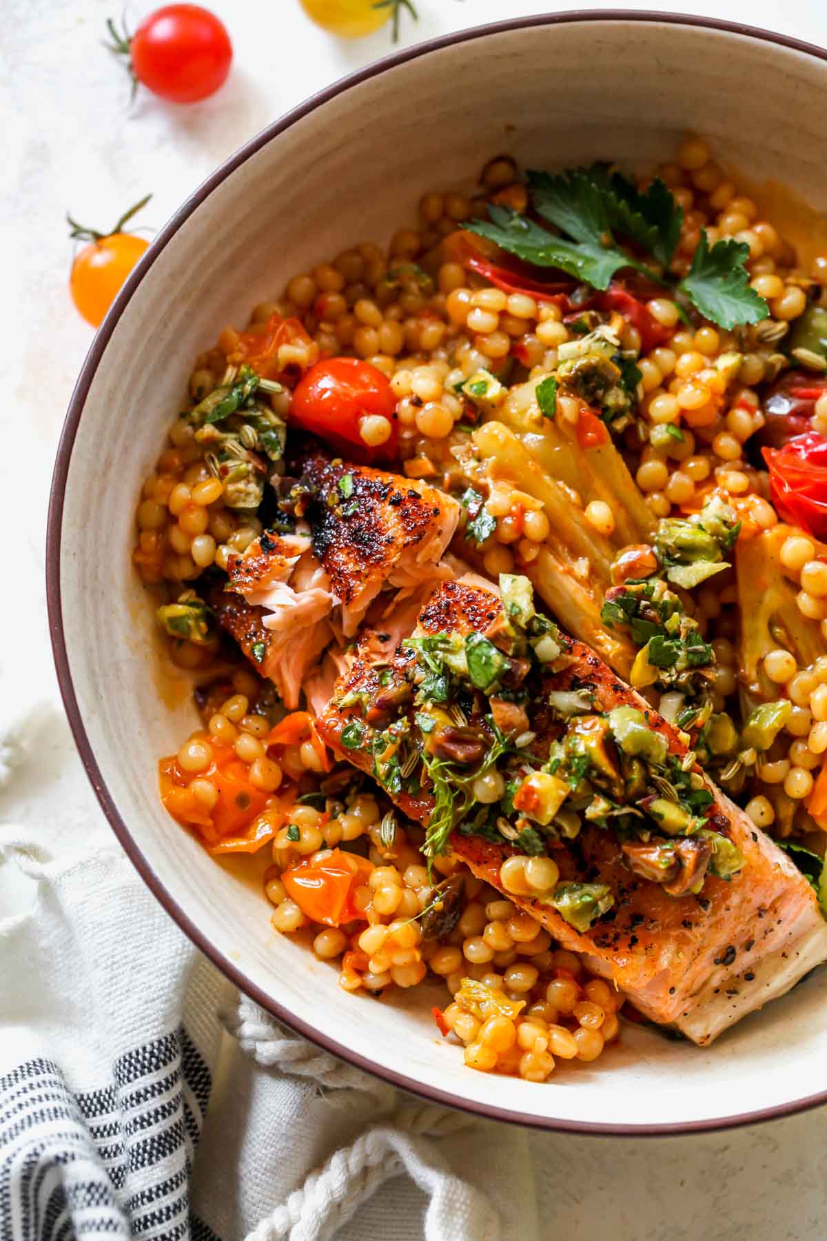 A fork flaking a piece of Mediterranean salmon in a bowl