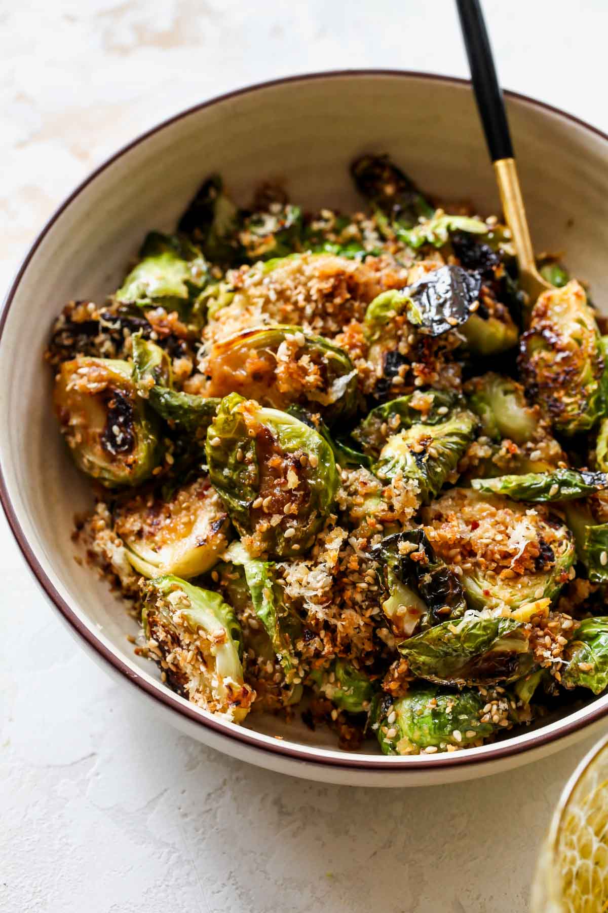 Bowl of miso glazed Brussels sprouts with a serving spoon