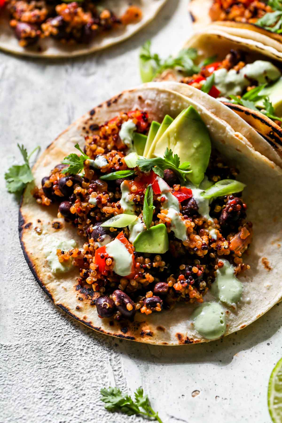 Charred tortilla filled with quinoa, black beans, and cilantro sauce