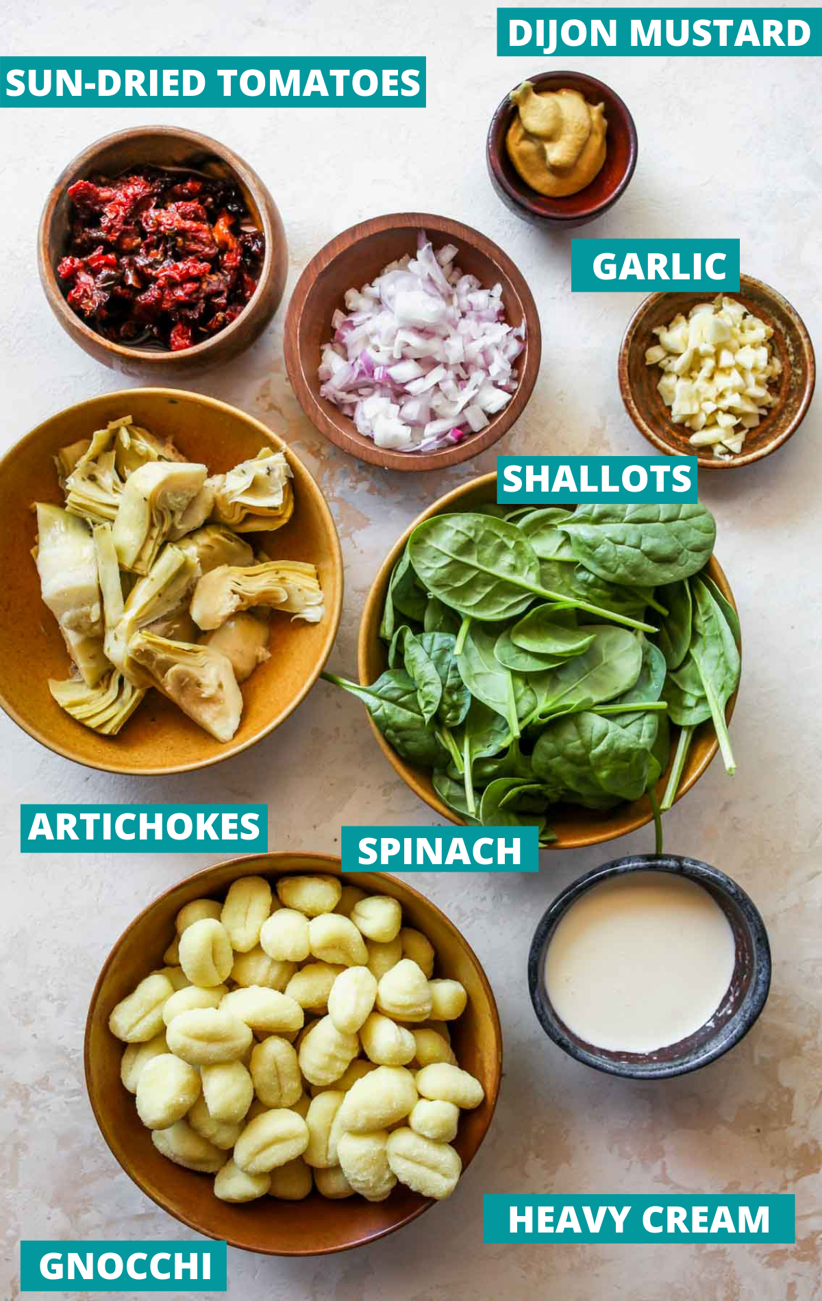 Recipe ingredients on a white board in separate bowls with blue labels.