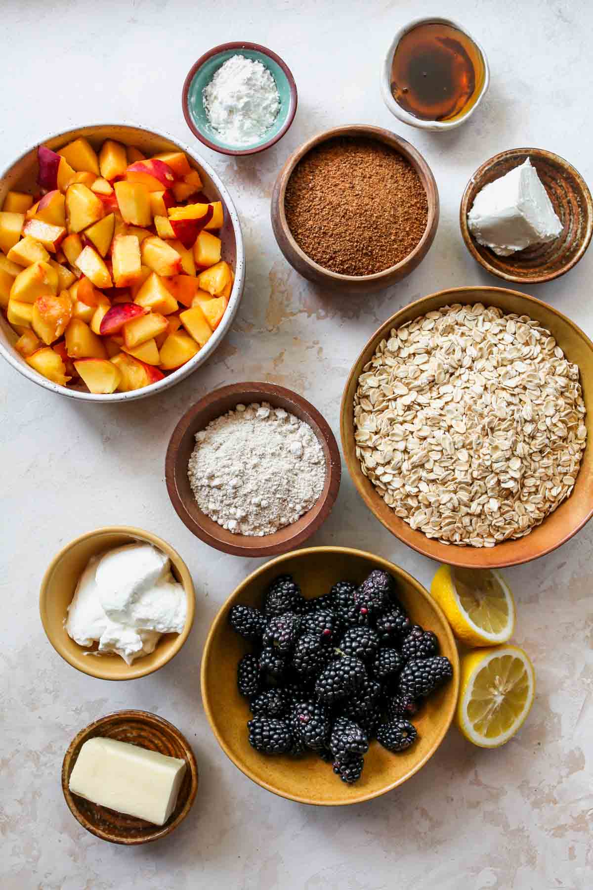 Fruit crisp ingredients in separate bowls on a white board