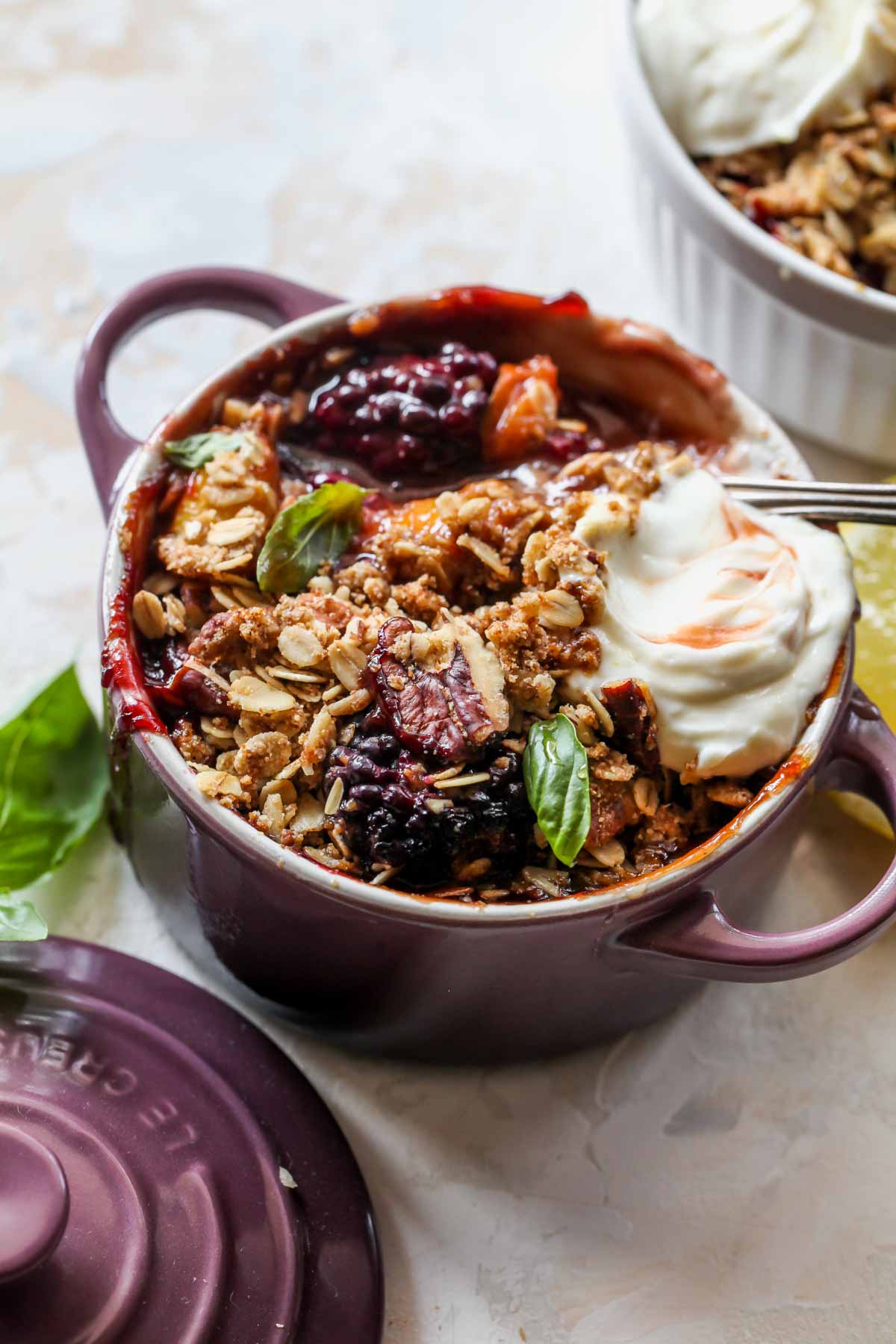 Peach and blackberry crisp topped with oat crumble and whipped goat cheese