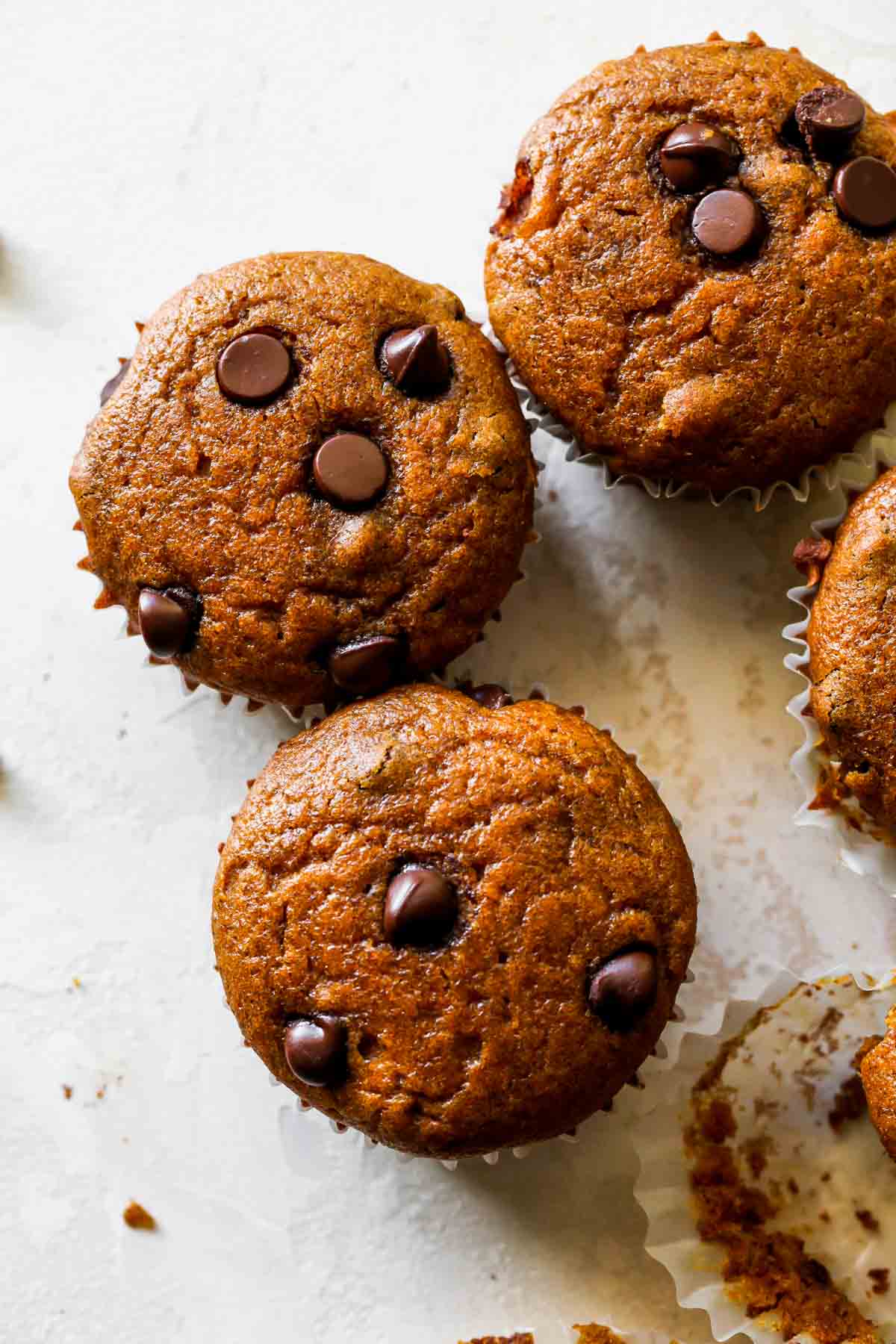 Four Pumpkin Chocolate Chip Muffins lined up next to eachother