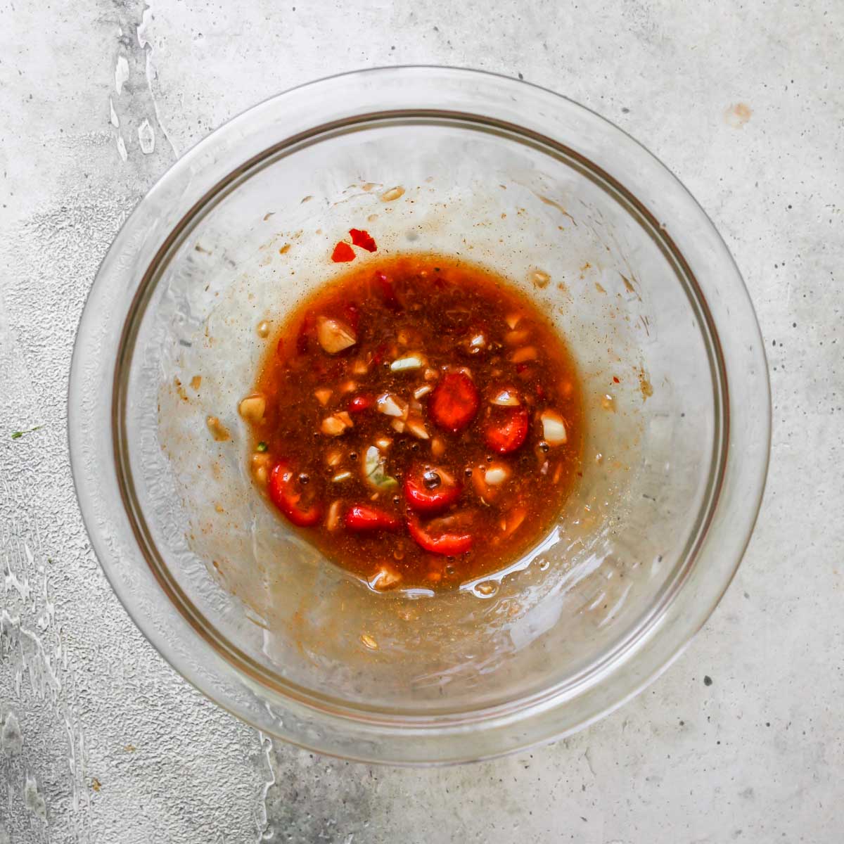 Chili-Garlic sauce being mixed in a clear bowl.