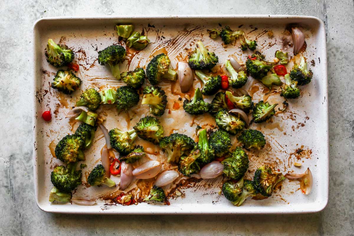 Roasted broccoli with chiles and garlic on a white sheet pan