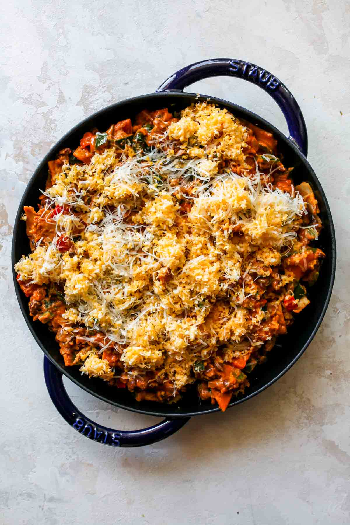 Shredded cheese on top of a pan of enchiladas before baking
