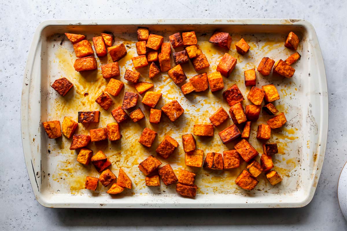 Cubes of butternut squash on a baking sheet after being roasted