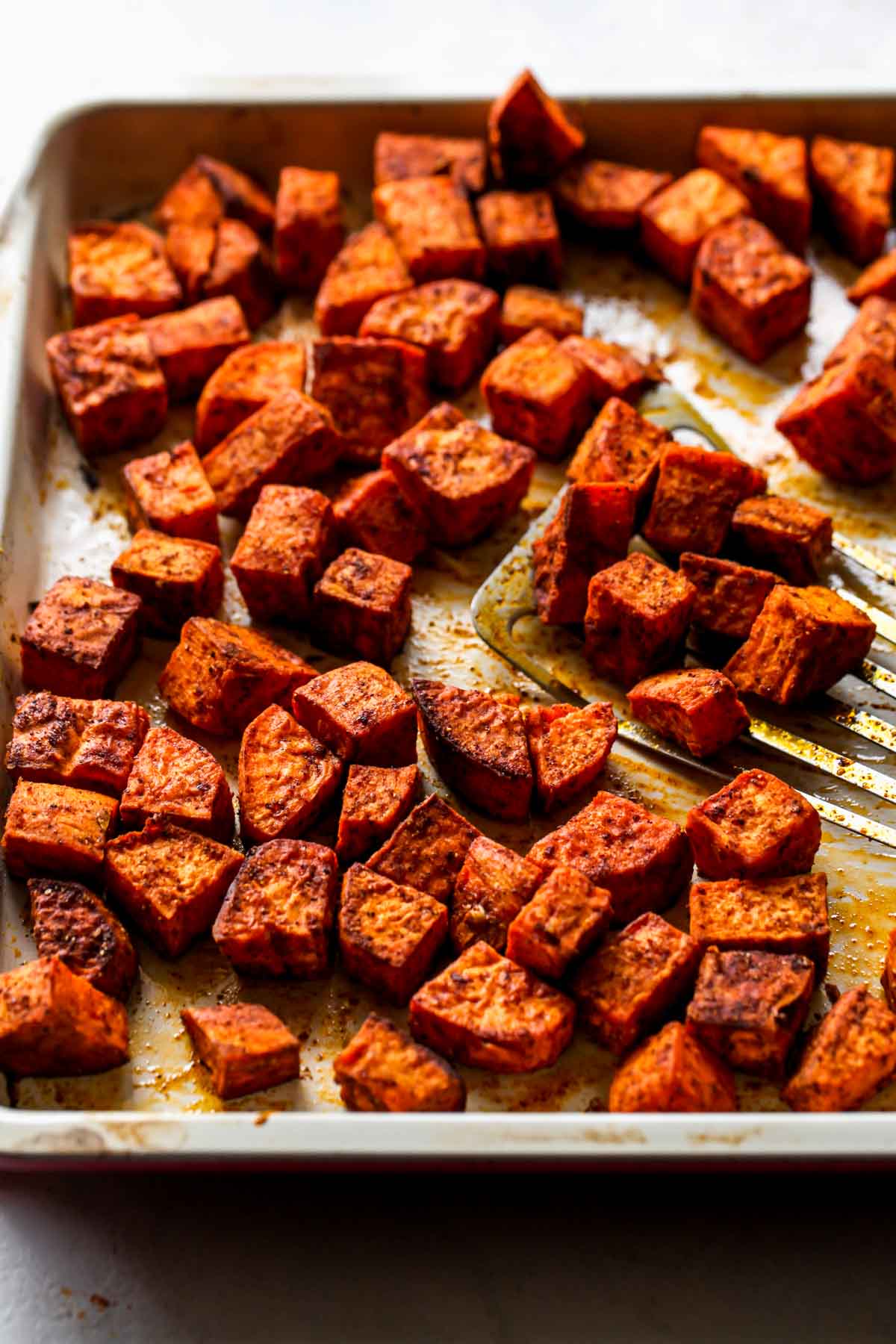 Cubes of roasted sweet potatoes on a baking sheet