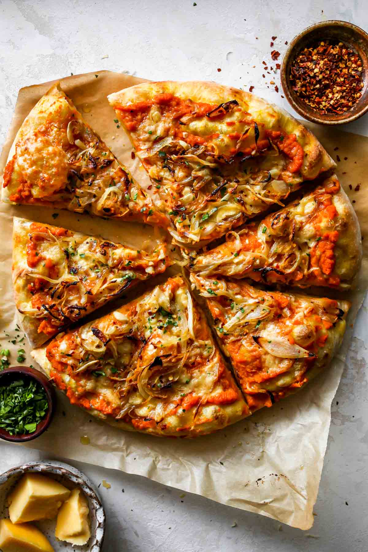 Pumpkin pizza sliced on a cutting board