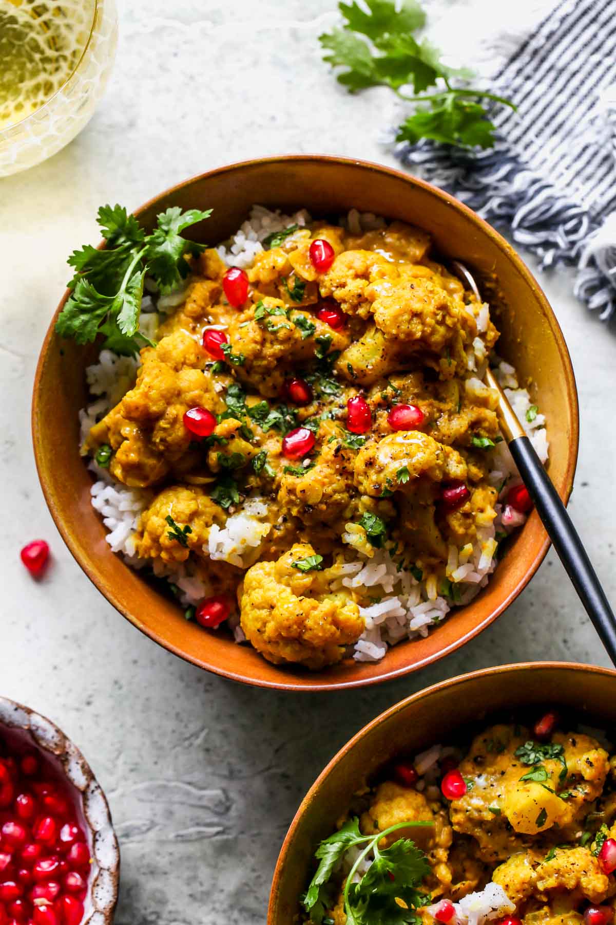 Cauliflower and lentil curry served over white rice in a gold bowl