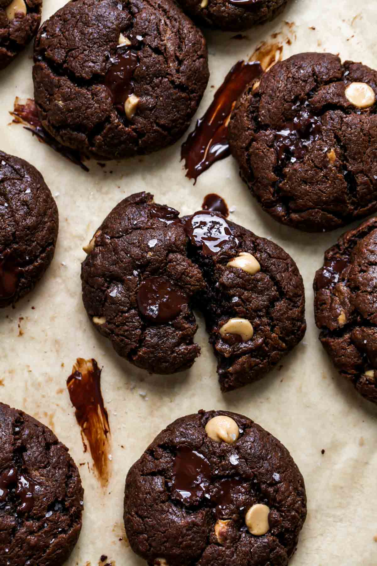 A cookie broken in half on a piece of parchment paper