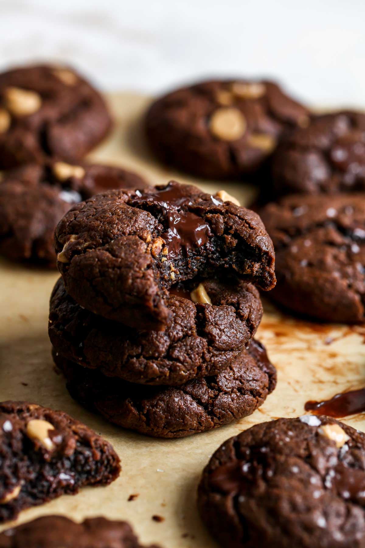 3 chocolate cookies stacked on top of each other on a piece of parchment paper