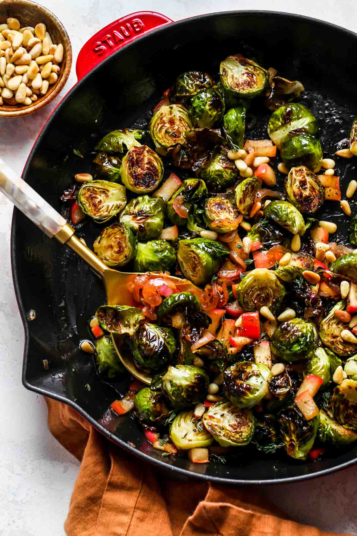 Glazed Brussels in a skillet with a serving spoon resting on the left side.
