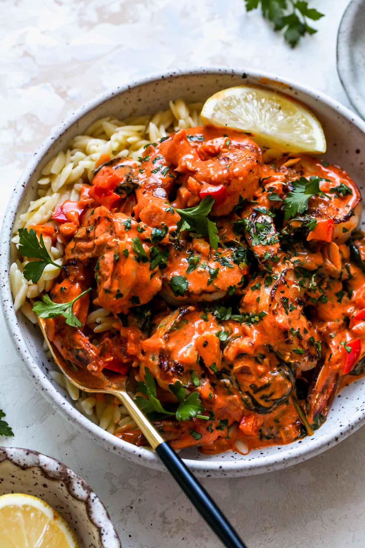 Orzo and sauteed prawns in a creamy garlic sauce styled in a white bowl