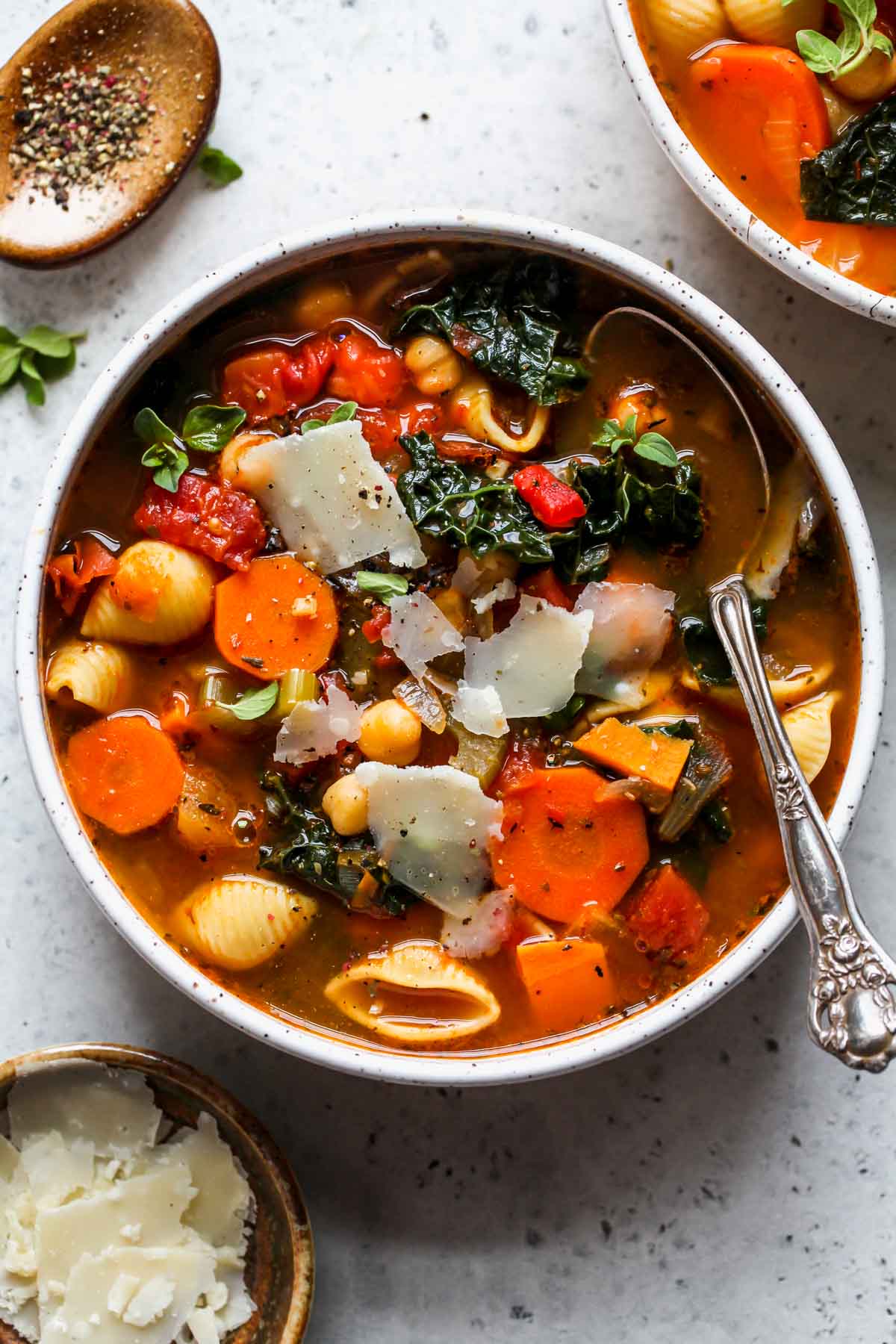 Bowl of minestrone soup with a soup resting on the right side