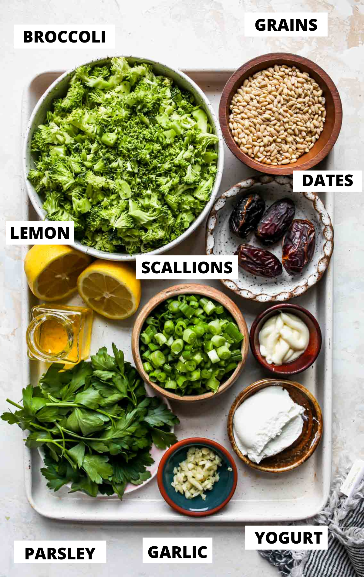 Recipe ingredients in separate bowls on a white sheet pan with labels