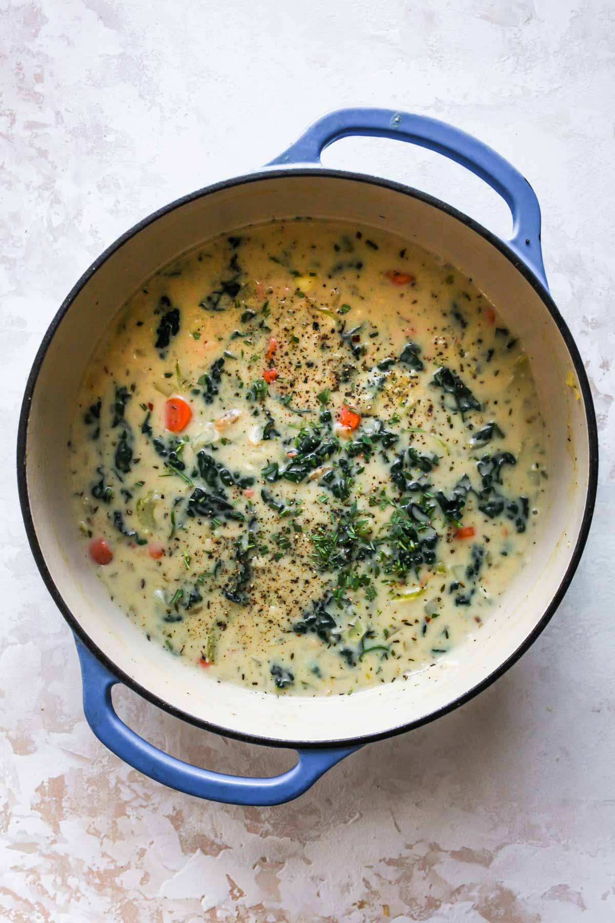 Gnocchi soup simmering in a blue Dutch oven