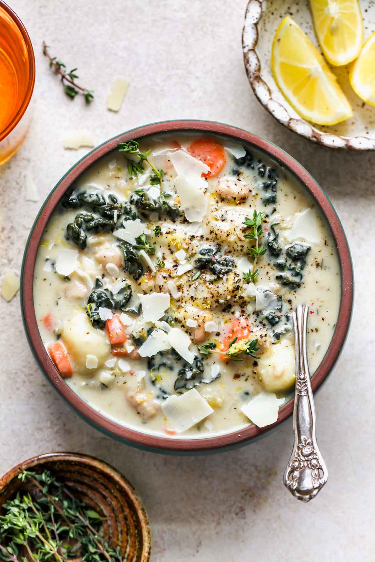 Vegetarian gnocchi soup in a serving bowl with a spoon resting on the right side