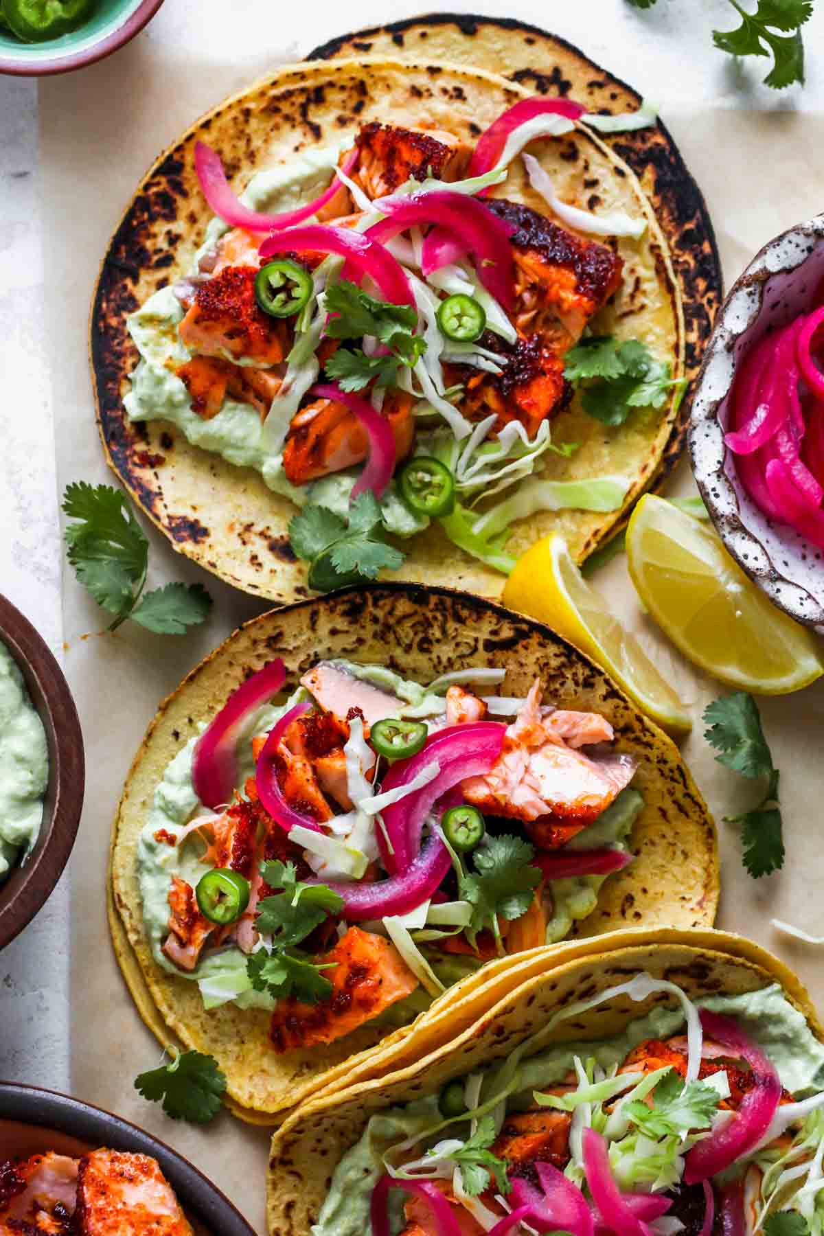 Salmon tacos styled on a piece of parchment paper.
