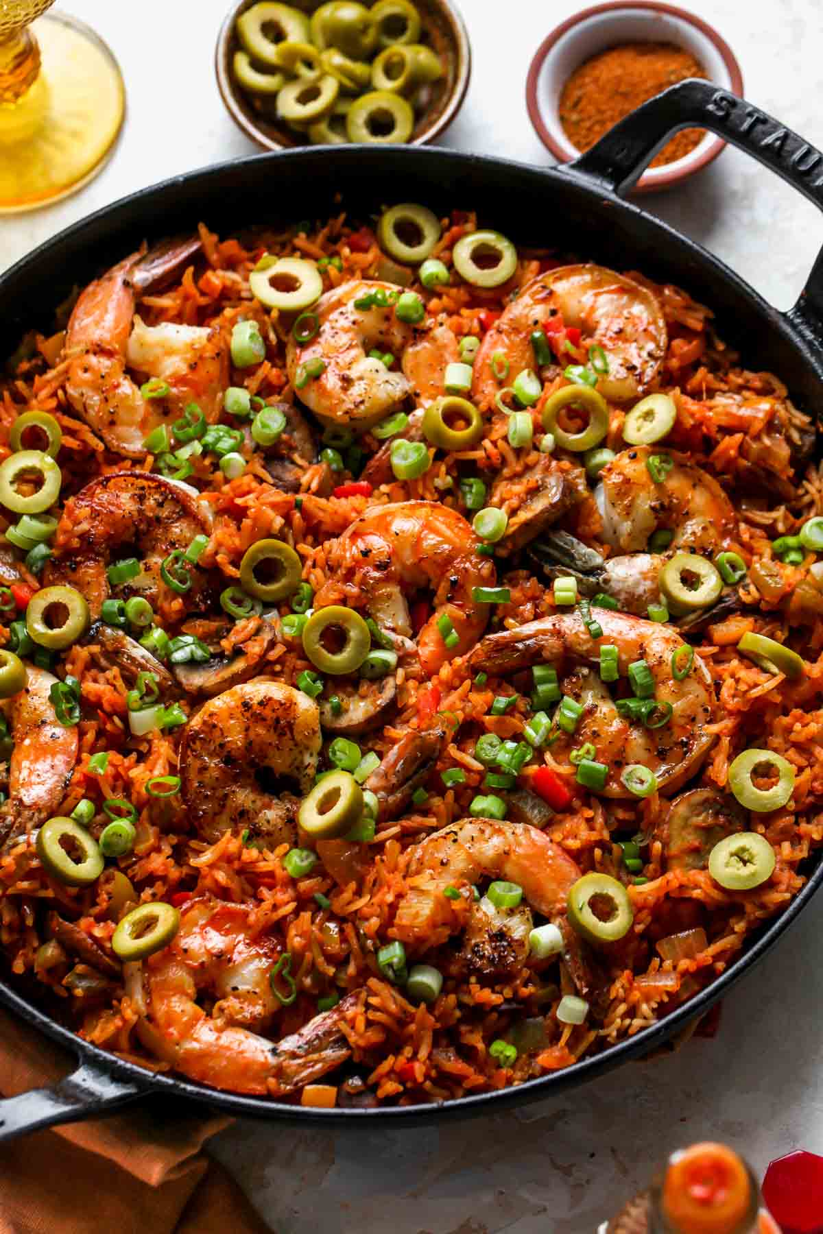 Shrimp Jambalaya in a black skillet topped with olives and green onion