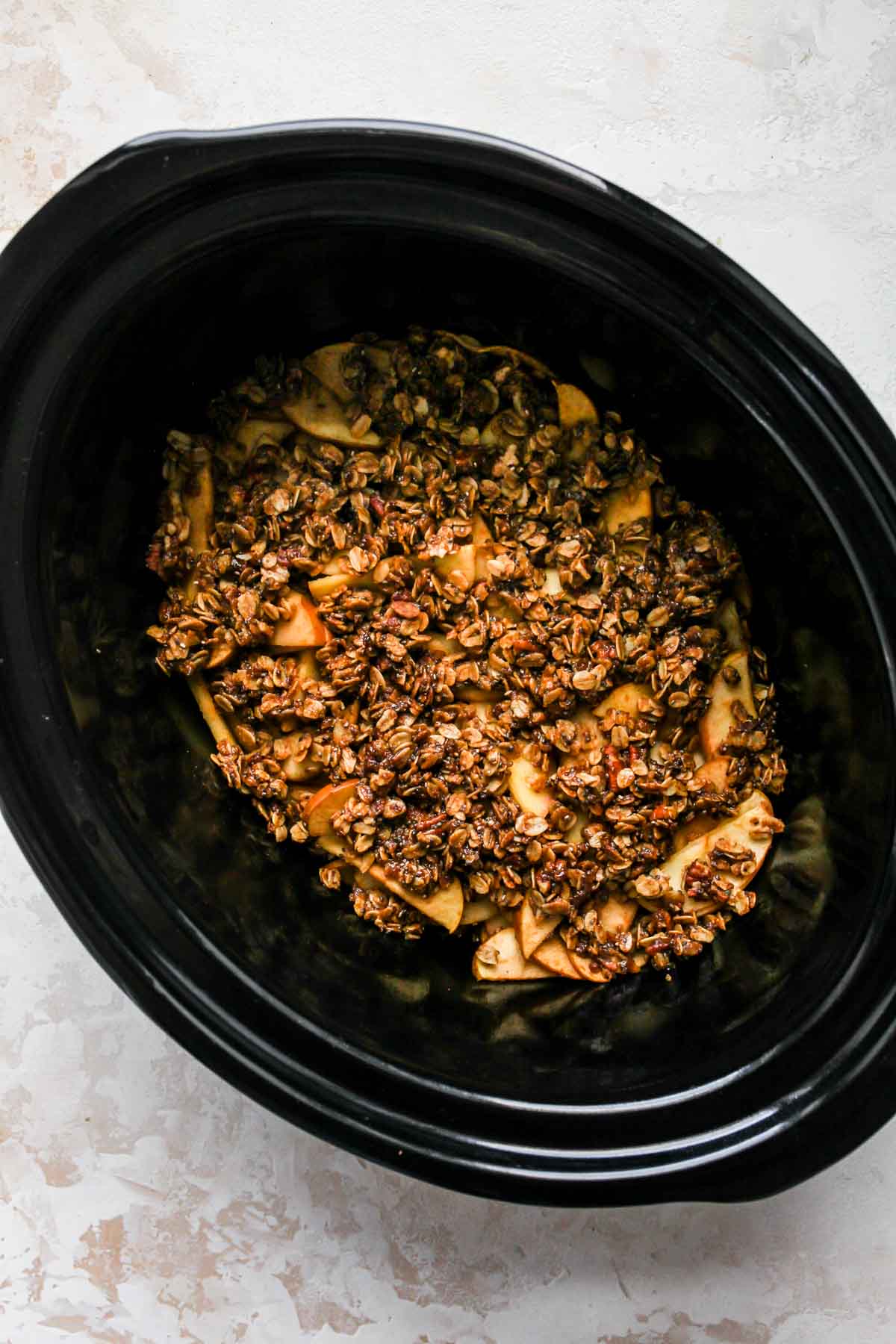 Apple crumble in a black slow cooker
