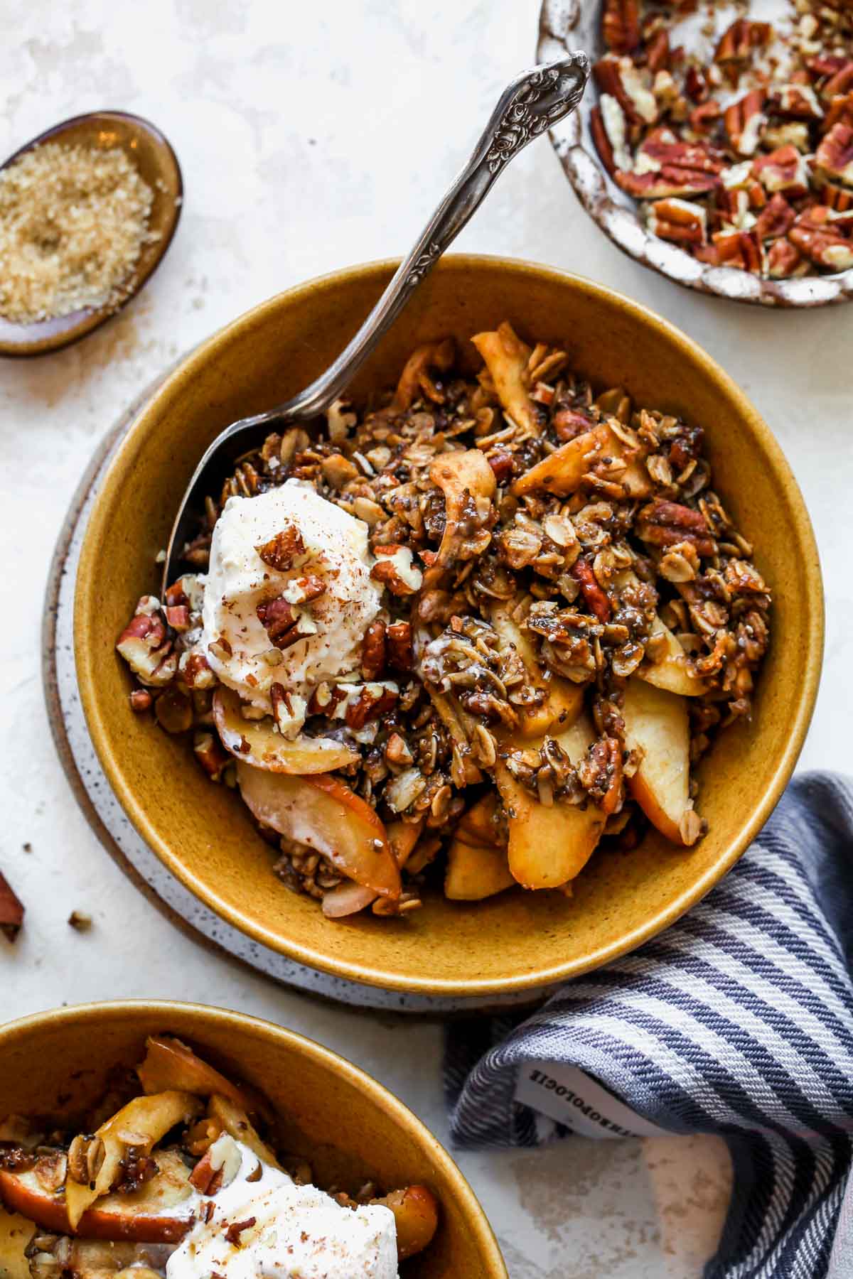 Apple pie crumble in a gold bowl topped with a scoop of ice cream