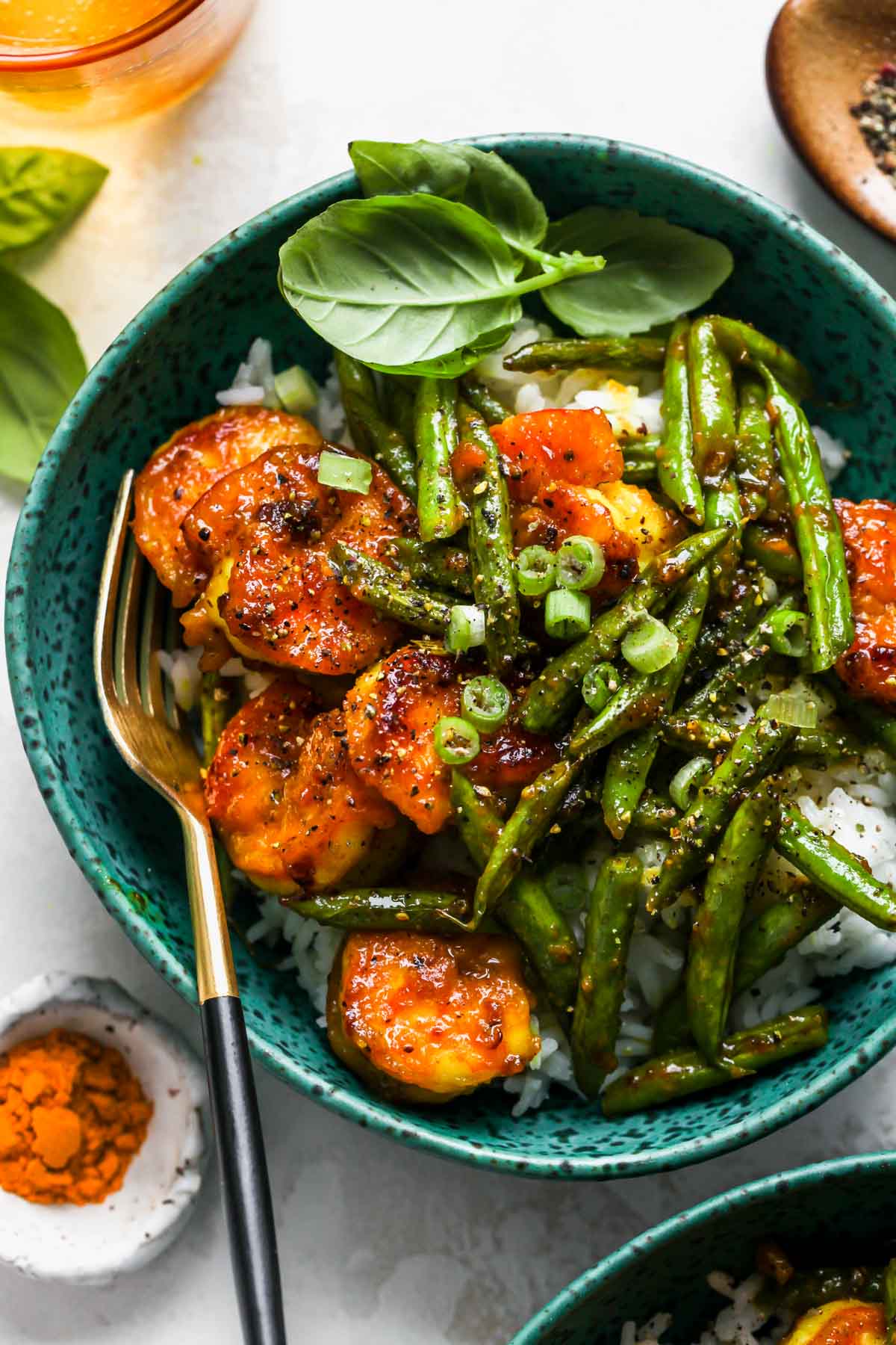 Shrimp and green beans served over rice in a teal bowl