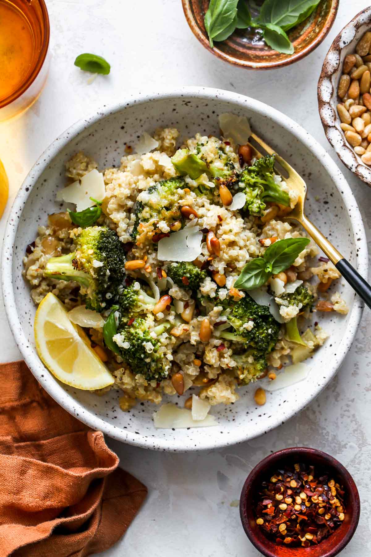 Bowl of cheesy broccoli casserole with a lemon wedge on the side