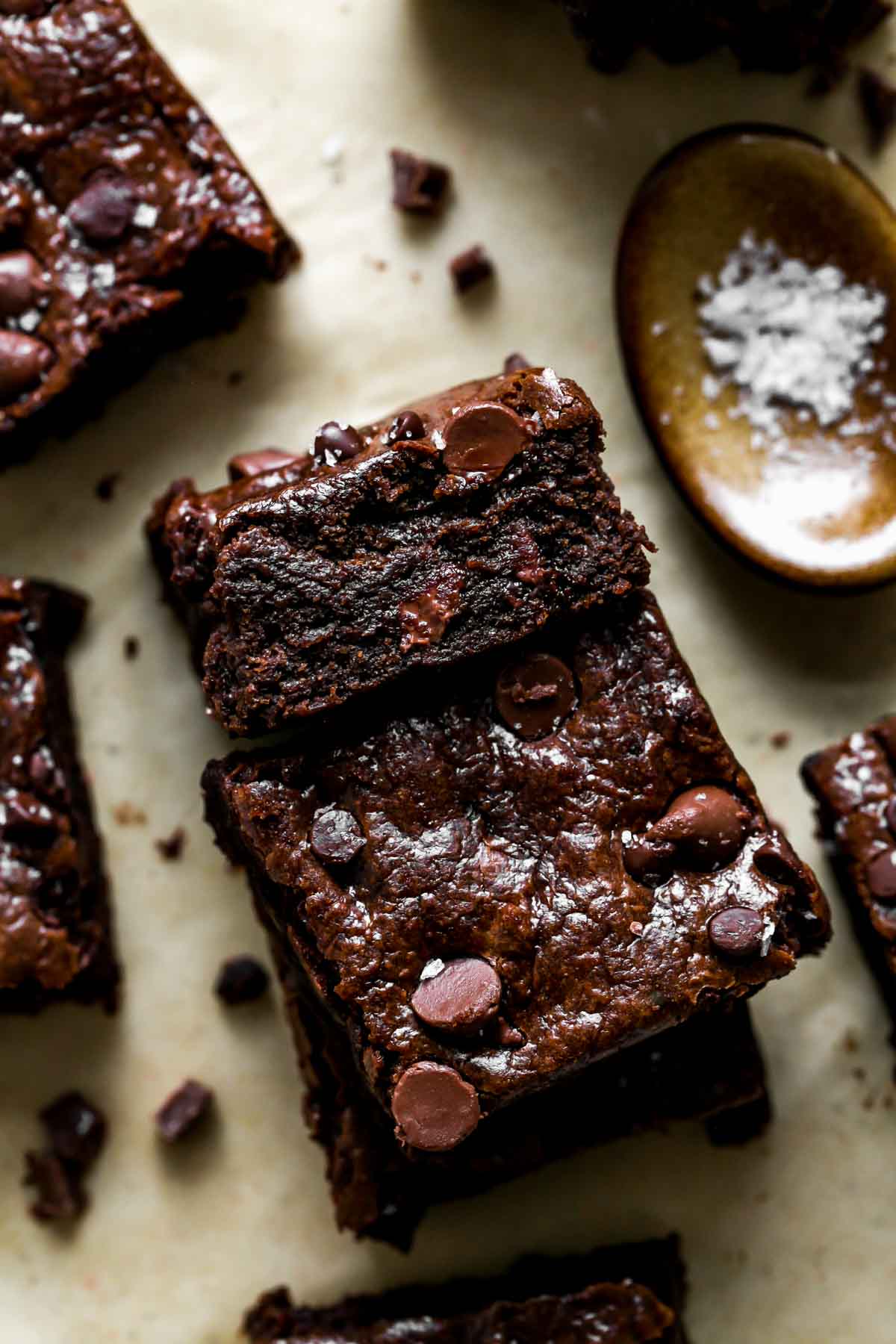 Brownies stacked on a piece of parchment paper