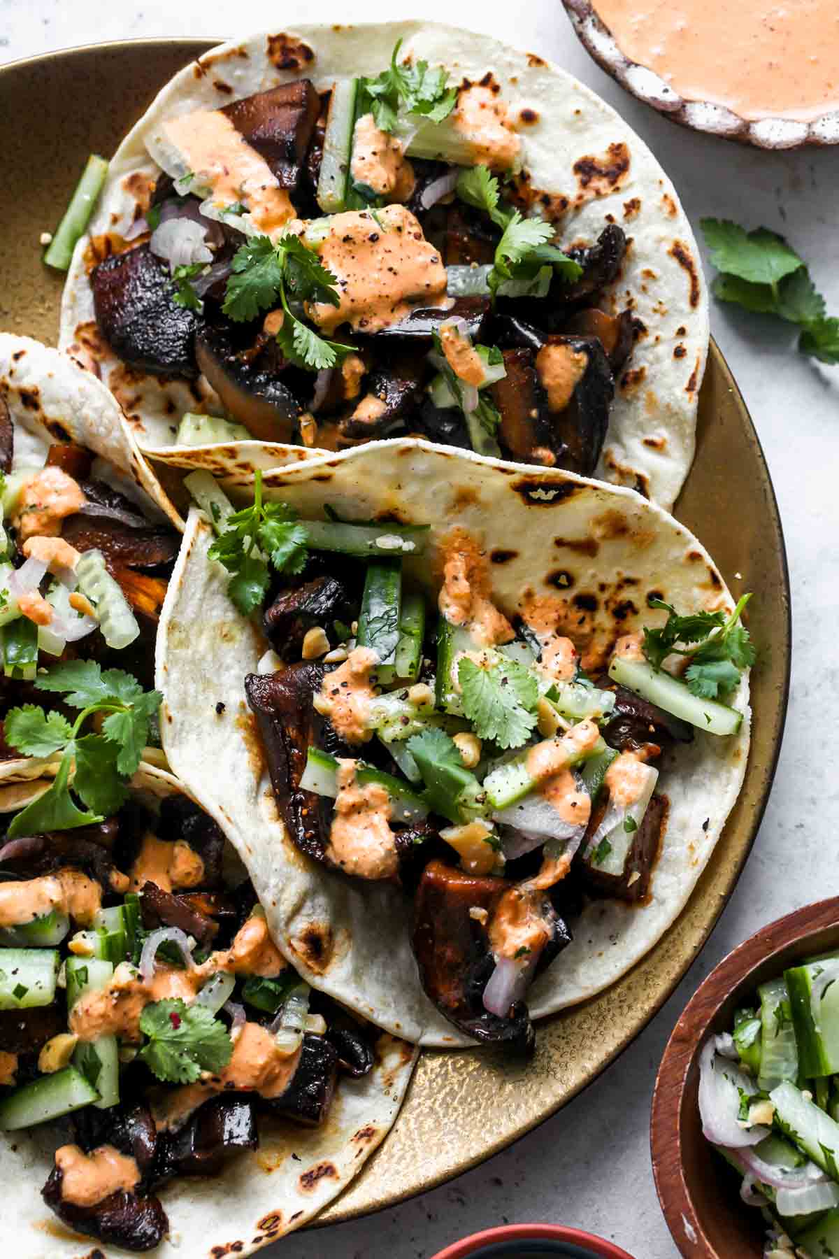 Eggplant and mushroom tacos topped with cucumber slaw and kimchi cream