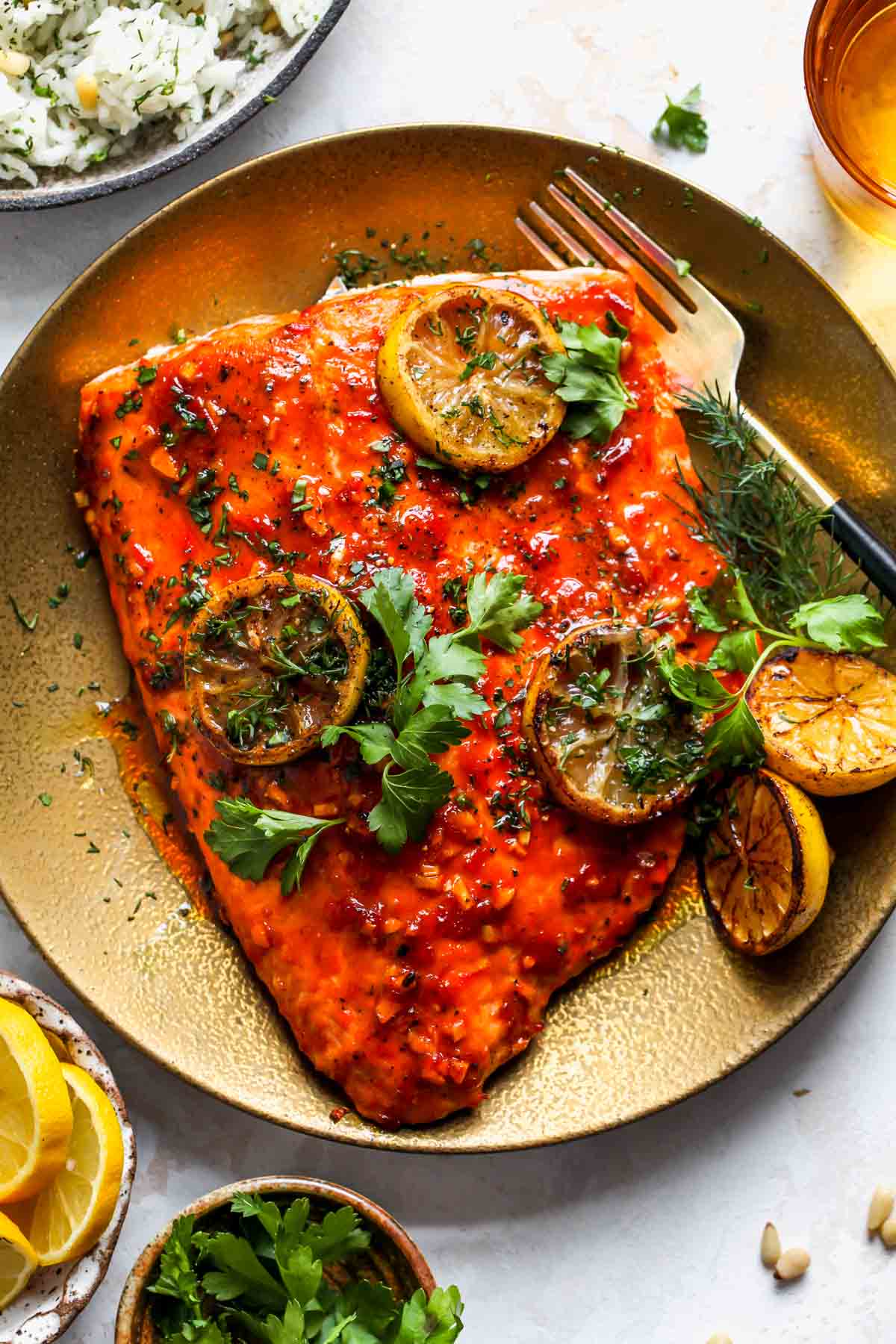 Honey-Harissa roasted salmon on a plate topped with lemon slices