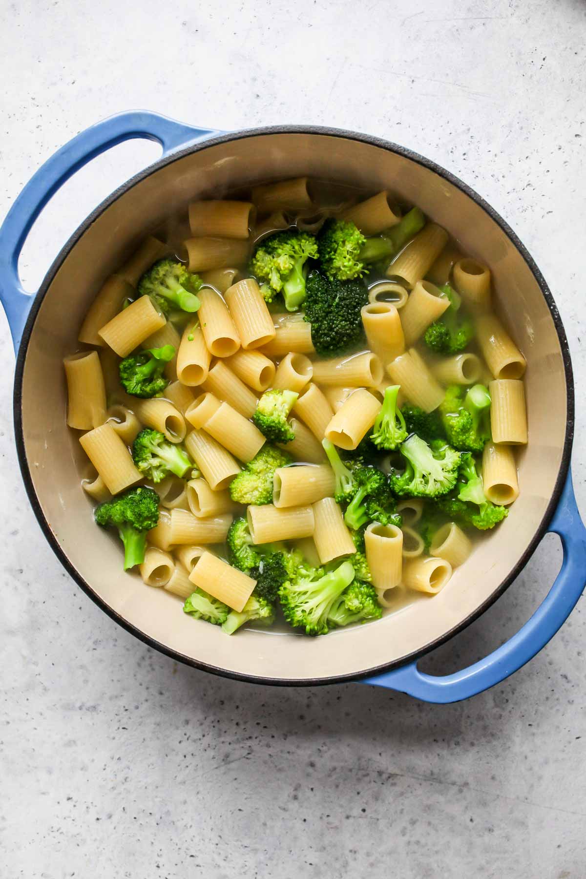 Rigatoni and broccoli florets boiling in a pot