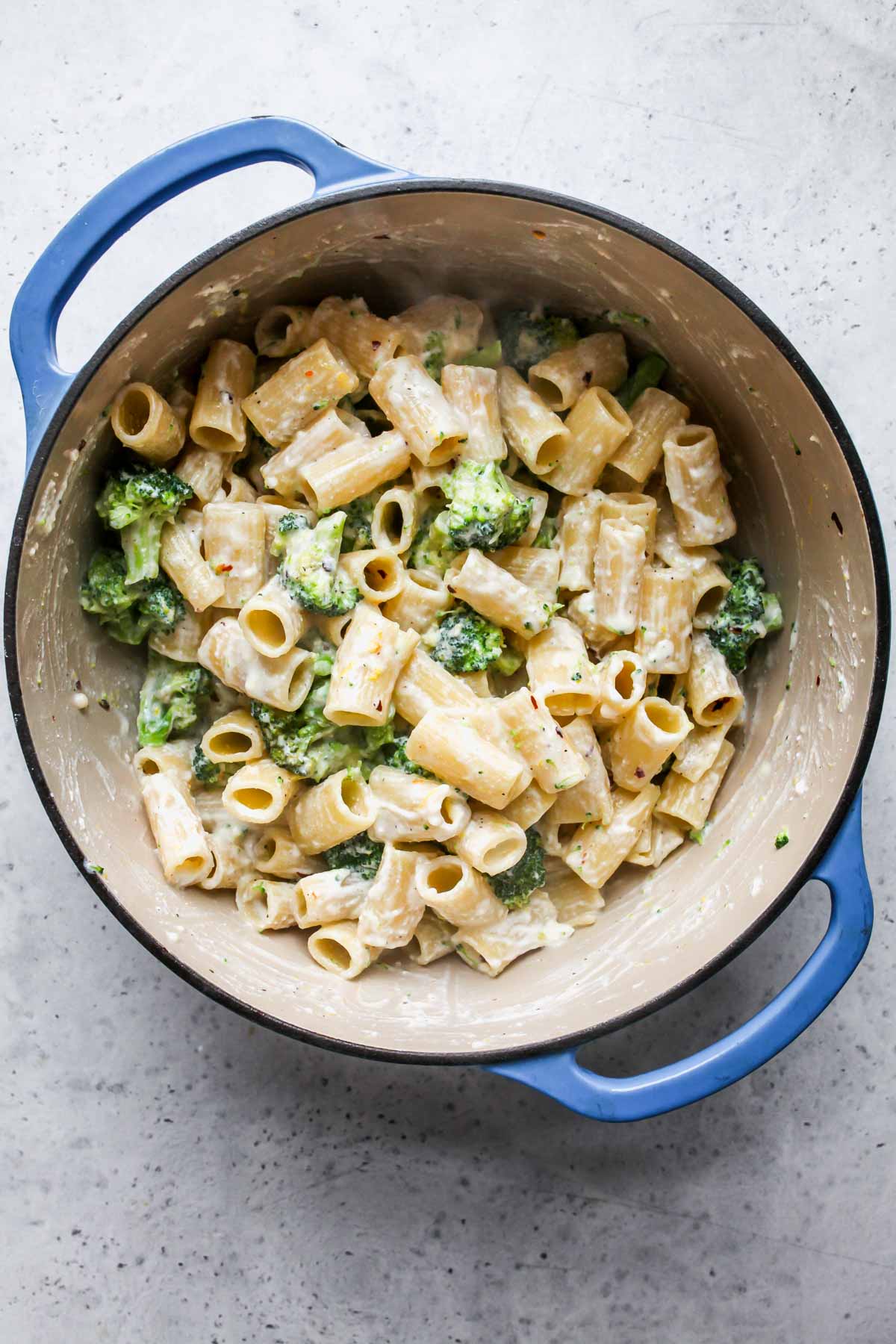 Sauce being mixed into pasta in a pot