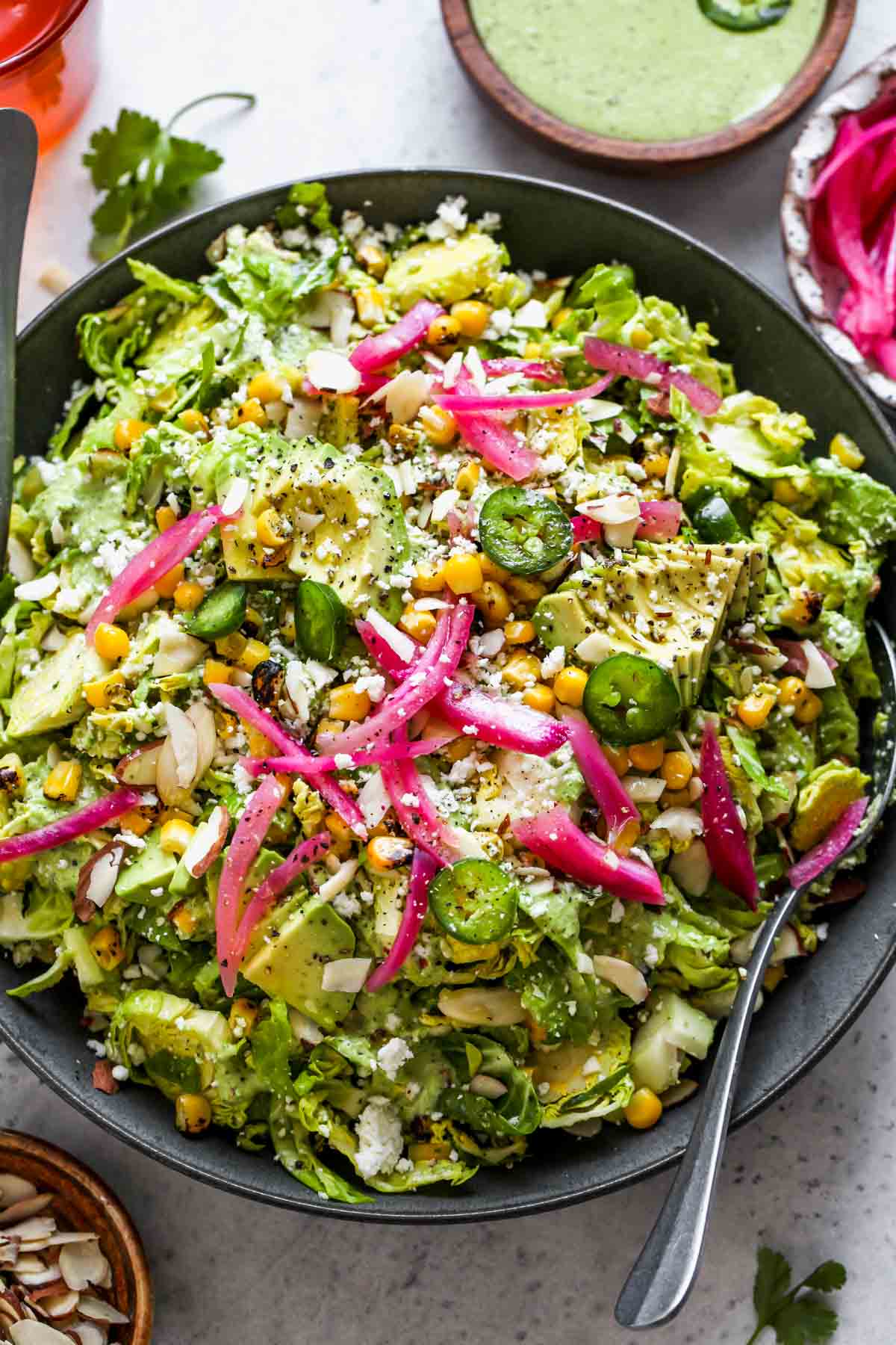 Mexican Brussels Sprouts Salad tossed in tomatillo dressing in a gray serving bowl