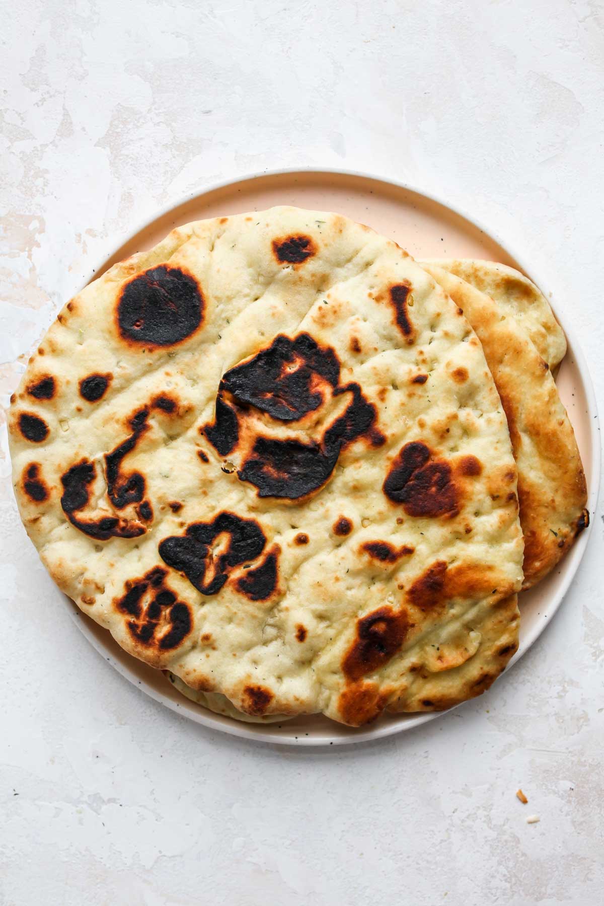 Grilled naan breads arranged on a plate