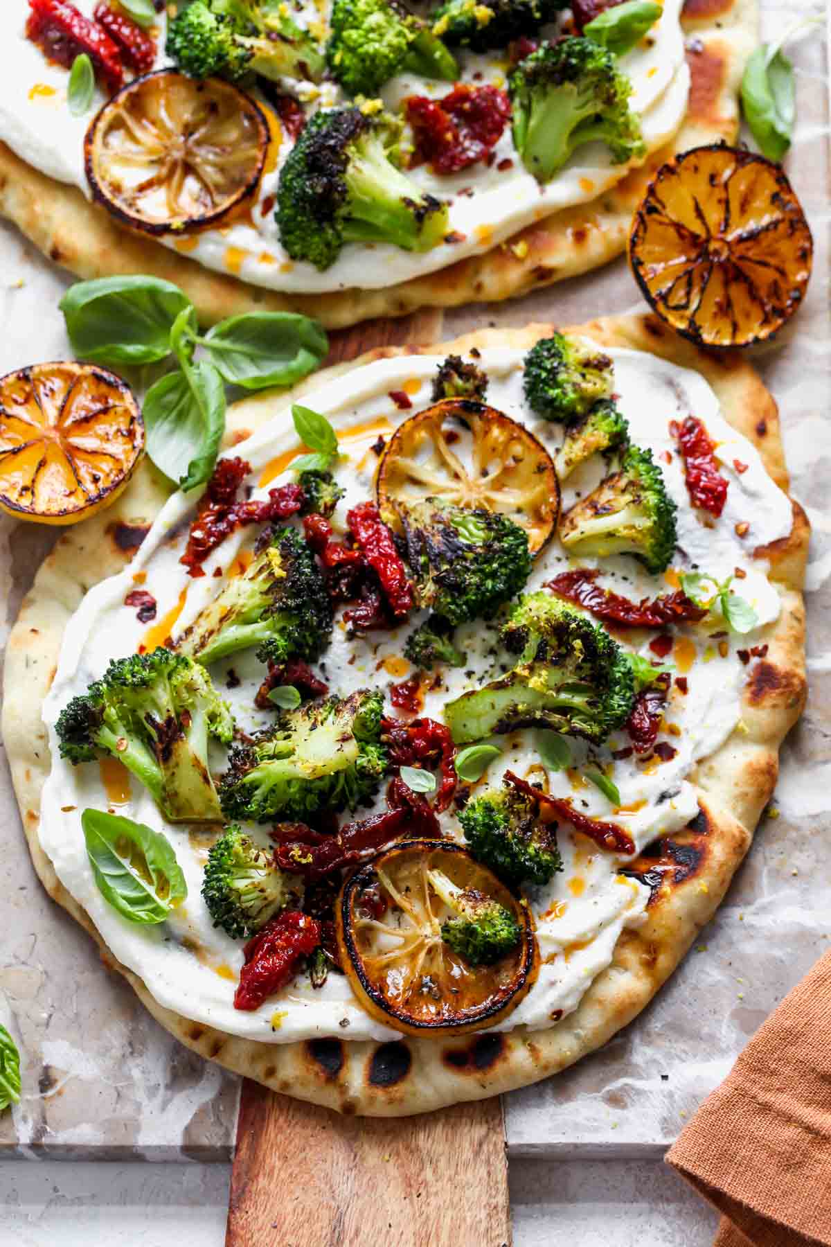 Assembled naan pizzas on a cutting board