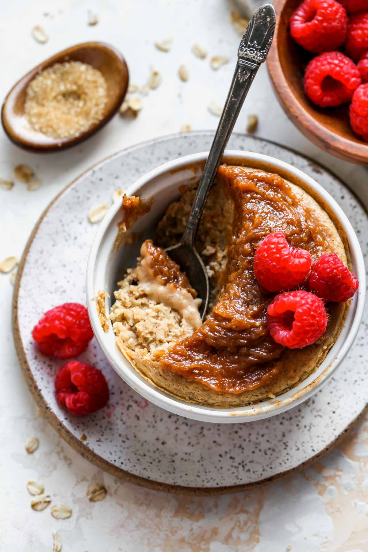 Peanut butter baked oatmeal topped with frosting and raspberries